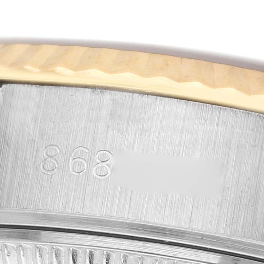 The image shows a close-up of the Rolex Datejust 69173 Women's Steel and Gold (two tone) Champagne Dial's fluted bezel and part of the case with engraved markings.