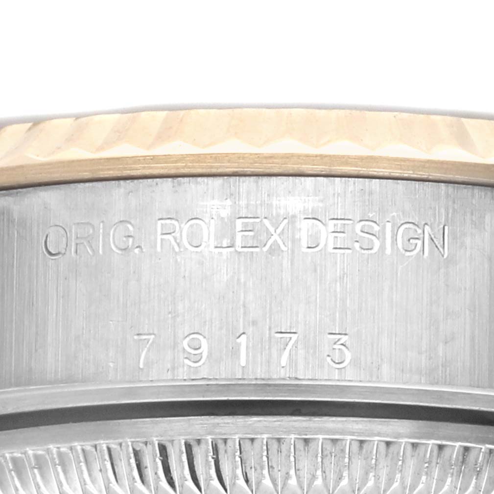 The image showcases a close-up of the side of a Rolex Datejust 79173 Women's Steel and Gold (two tone) Champagne Dial 79173 Women's Steel and Gold (two tone) Champagne Dial, focusing on the engravings and part of the bezel.