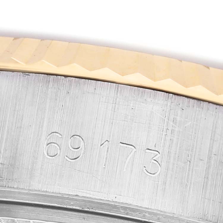 The image shows a close-up of the engraved model number and fluted bezel of a Rolex Datejust 69173 Women's Steel and Gold (two tone) White Dial watch.