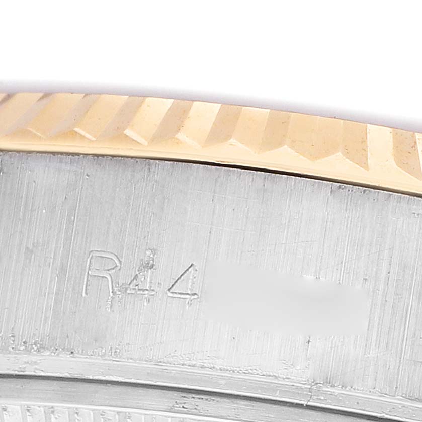 The image shows a close-up of the Rolex Datejust 69173 Women's Steel and Gold (two tone) White Dial model's fluted bezel and part of the inner watch case with engraved markings.