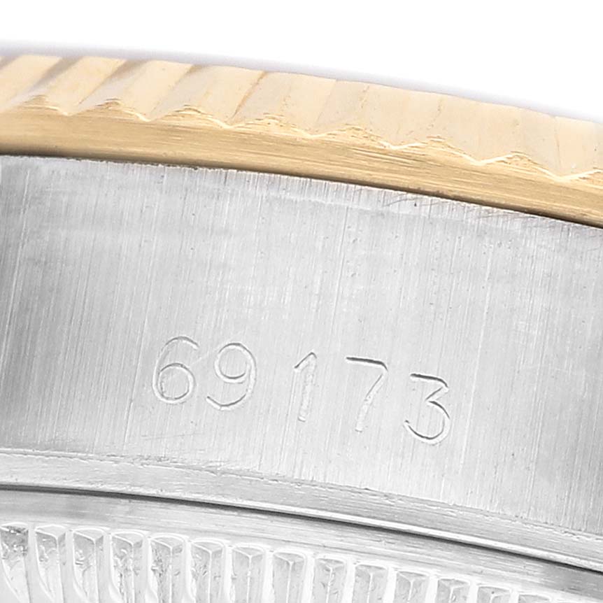 The image shows a close-up of the serial number on the side of a Rolex Datejust 69173 Women's Steel and Gold (two tone) White Dial watch case, with part of the bezel visible.