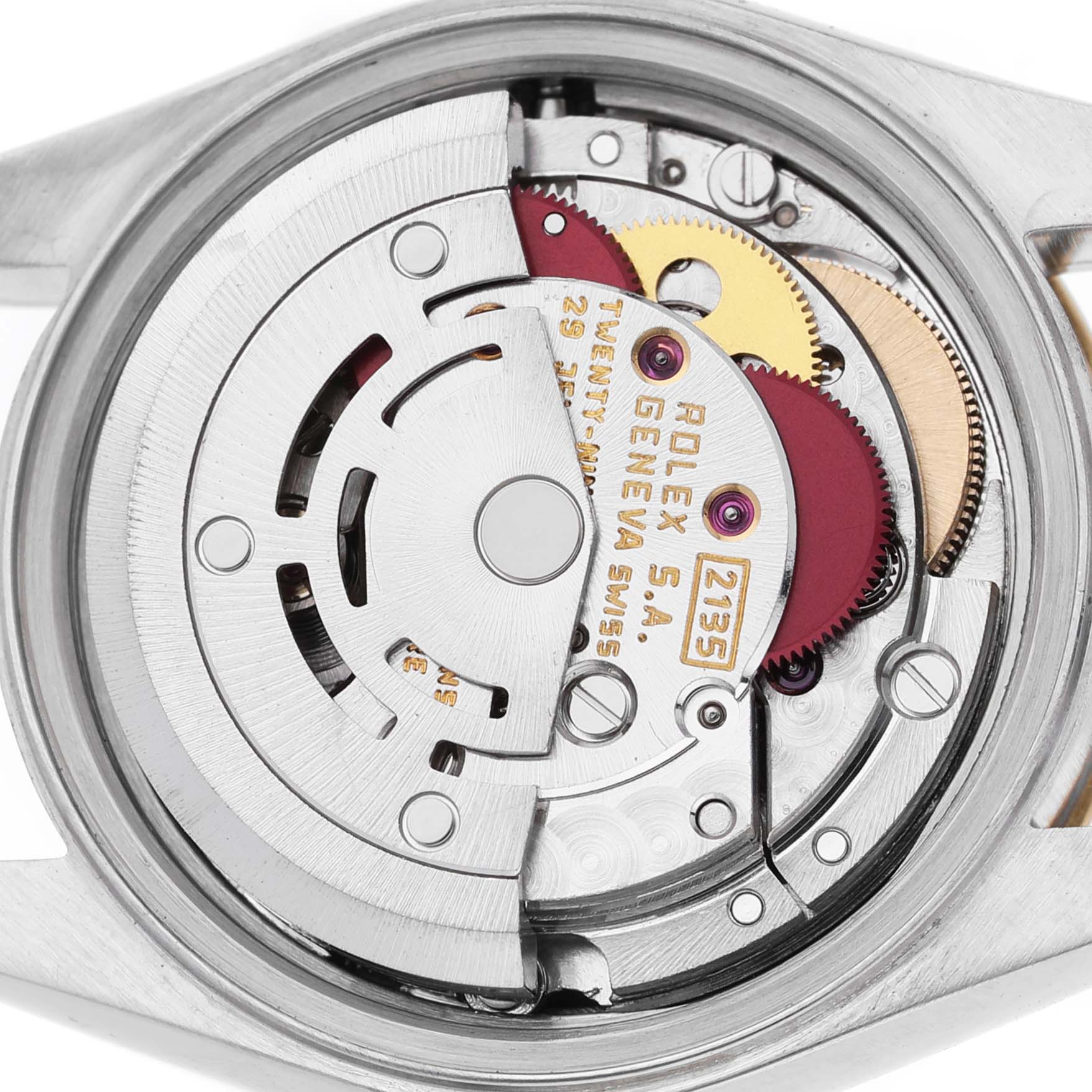 The image shows the movement mechanism of a Rolex Datejust 69173 Women's Steel and Gold (two tone) White Dial watch viewed from the back, revealing gears and parts.