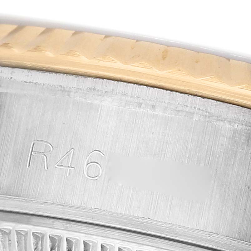 The image shows a close-up of the bezel and case side of a Rolex Datejust 69173 Women's Steel and Gold (two tone) White Dial, including engraved details.