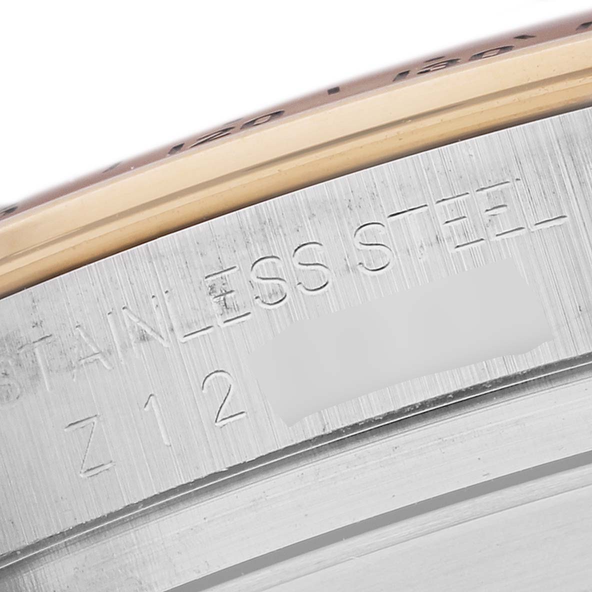 This image shows a close-up of the side case and engraving on a Rolex Daytona 116523 Men's Steel and Gold (two tone) Mother of Pearl Dial 116523 Men's Steel and Gold (two tone) Mother of Pearl Dial watch, highlighting "STAINLESS STEEL."