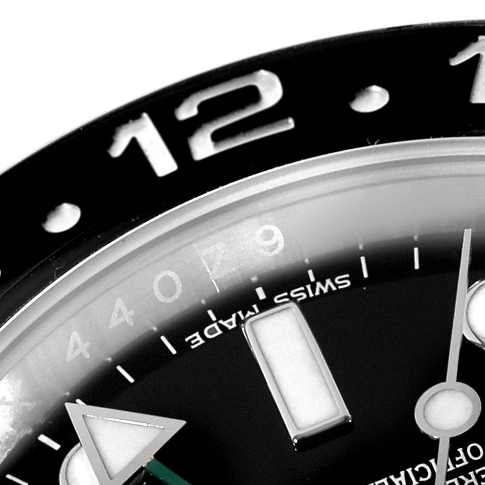 Close-up of the Rolex GMT-Master 116710 Men
s Stainless Steel Black Dial 116710 Men
s Stainless Steel Black Dial watch showing part of the bezel, hour markers, and hands.