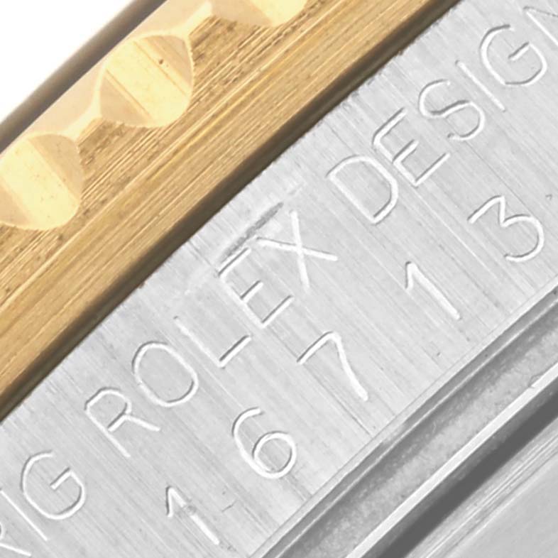 The image shows a close-up view of the Rolex GMT-Master 16713LN Men's Steel and Gold (two tone) Black Dial 16713LN Men's Steel and Gold (two tone) Black Dial model's engraved bezel and inner case details.