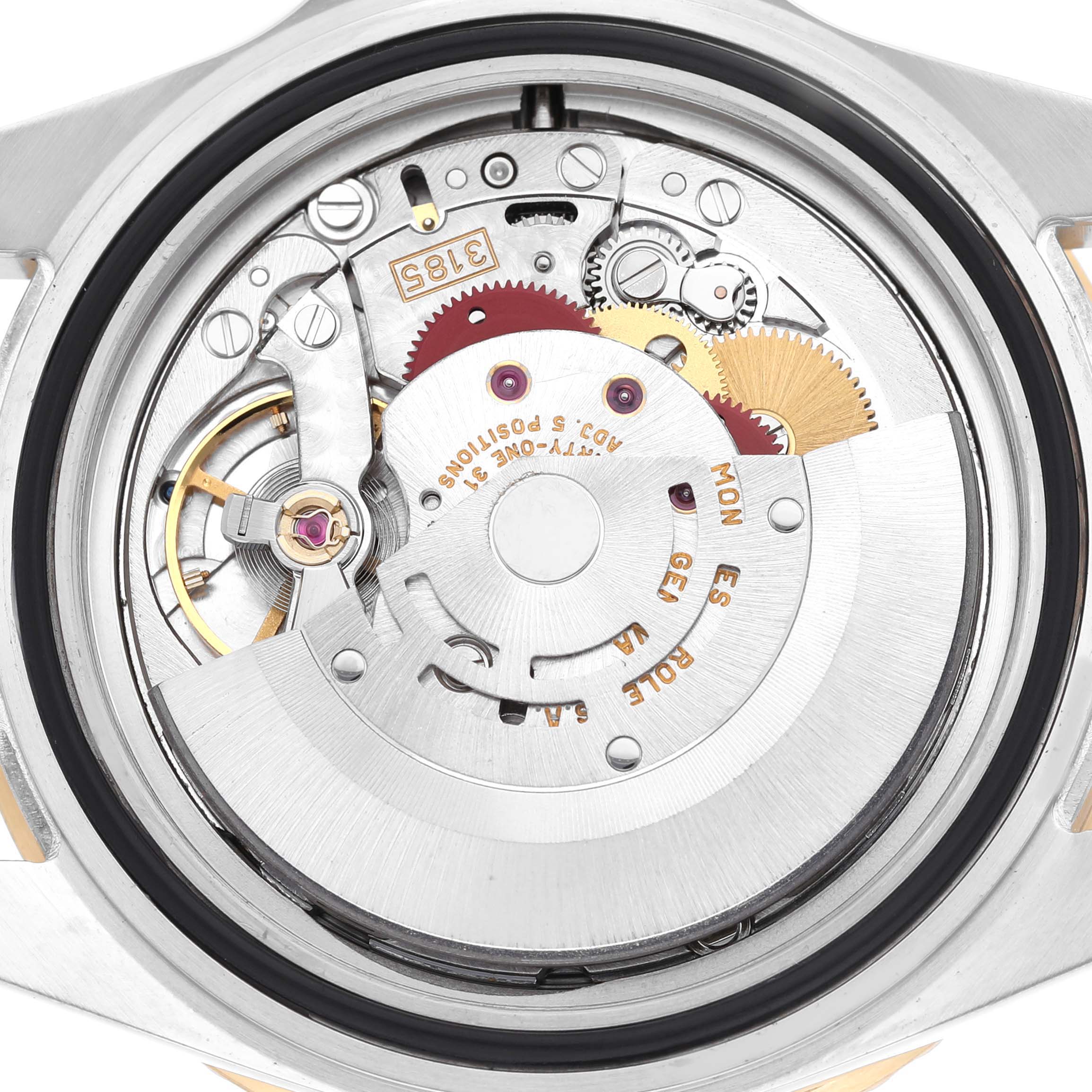 The image shows the movement of a Rolex GMT-Master 16713 Men's Steel and Gold (two tone) Black Dial watch from a rear angle, revealing intricate gears and components.