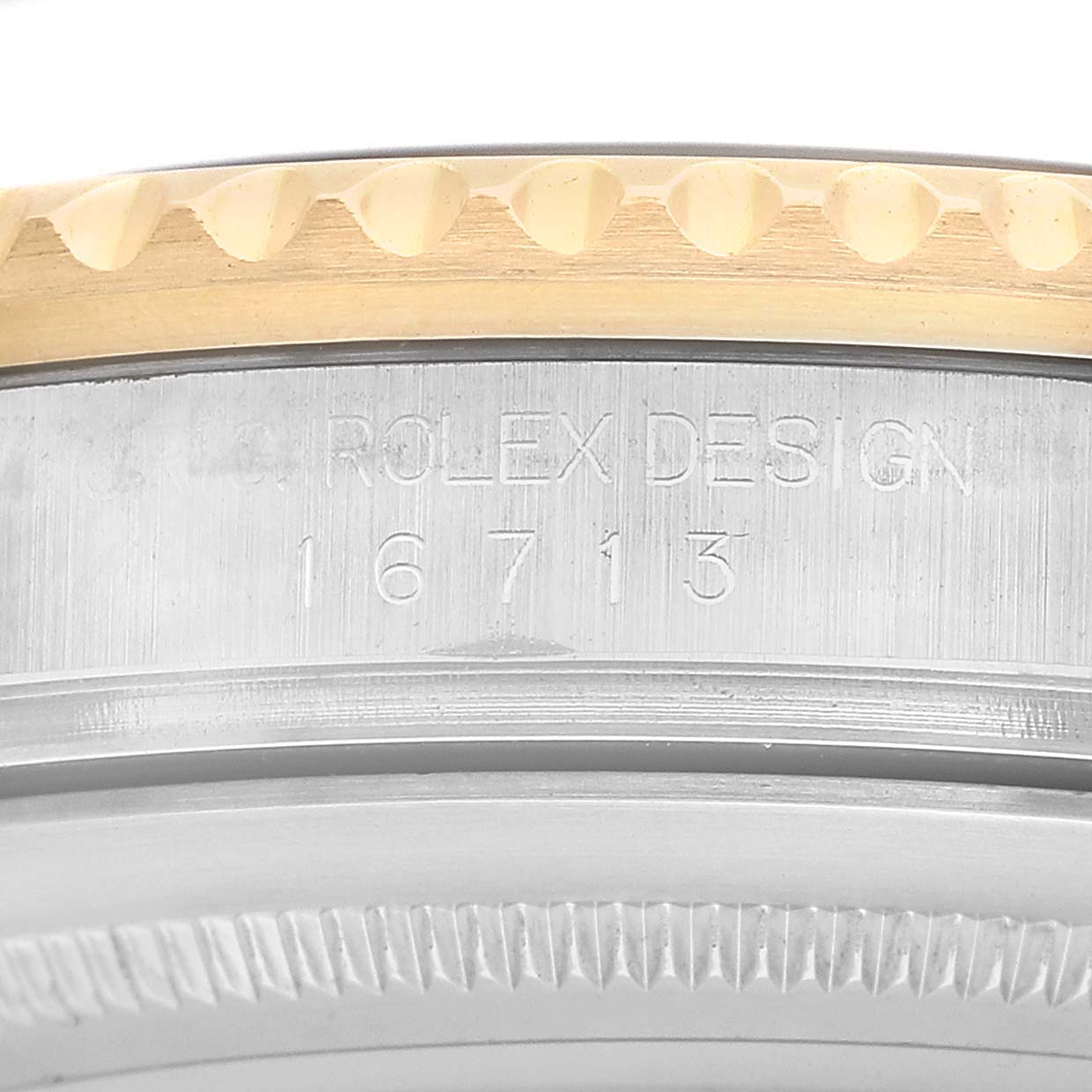 The image shows a close-up of the bezel and case edge of a Rolex GMT-Master 16713 Men's Steel and Gold (two tone) Black Dial watch, highlighting the model number engraving.