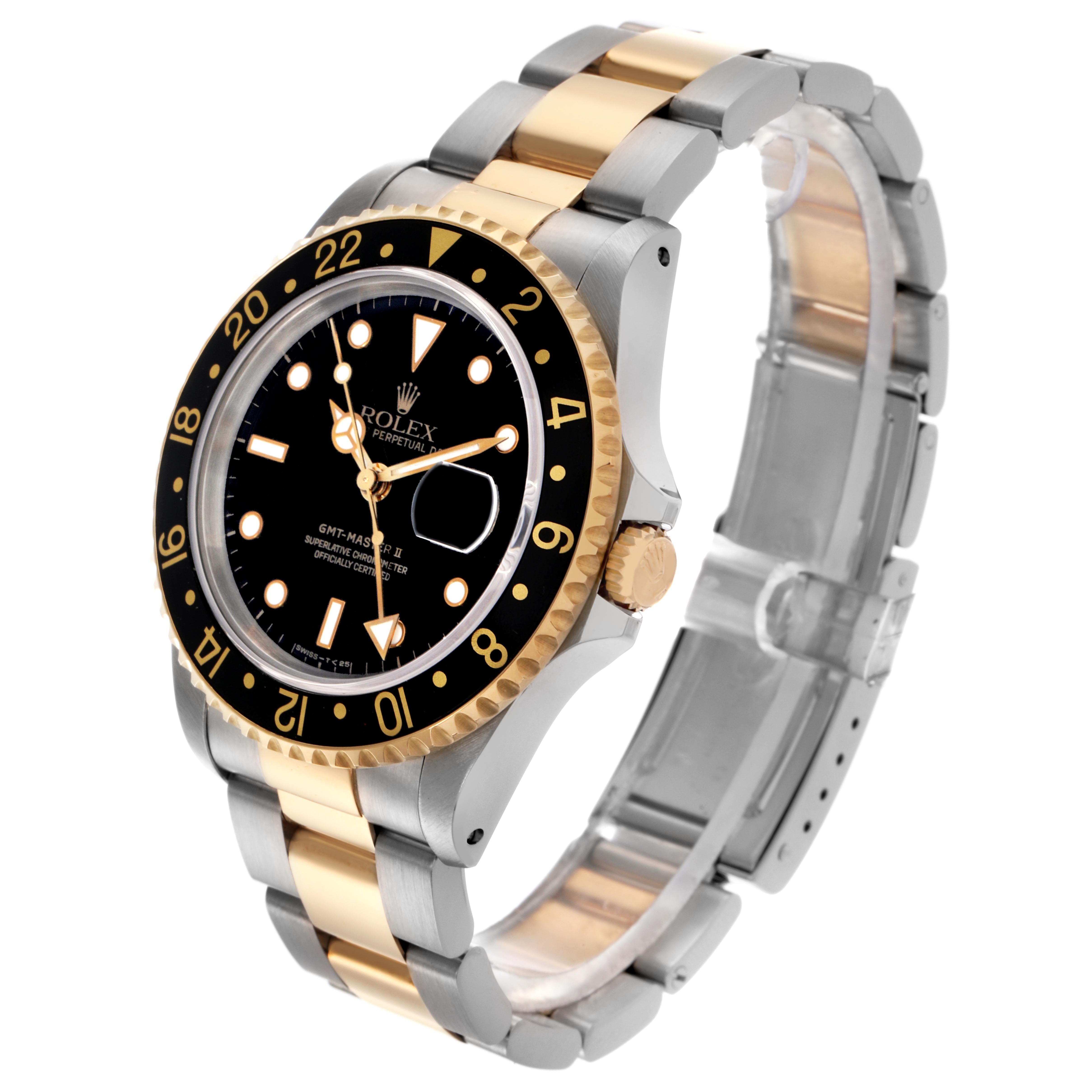 The Rolex GMT-Master 16713LN Men
s Steel and Gold (two tone) Black Dial 16713LN Men
s Steel and Gold (two tone) Black Dial watch is shown at a 3/4 angle, highlighting the dial, bezel, crown, and two-tone bracelet.