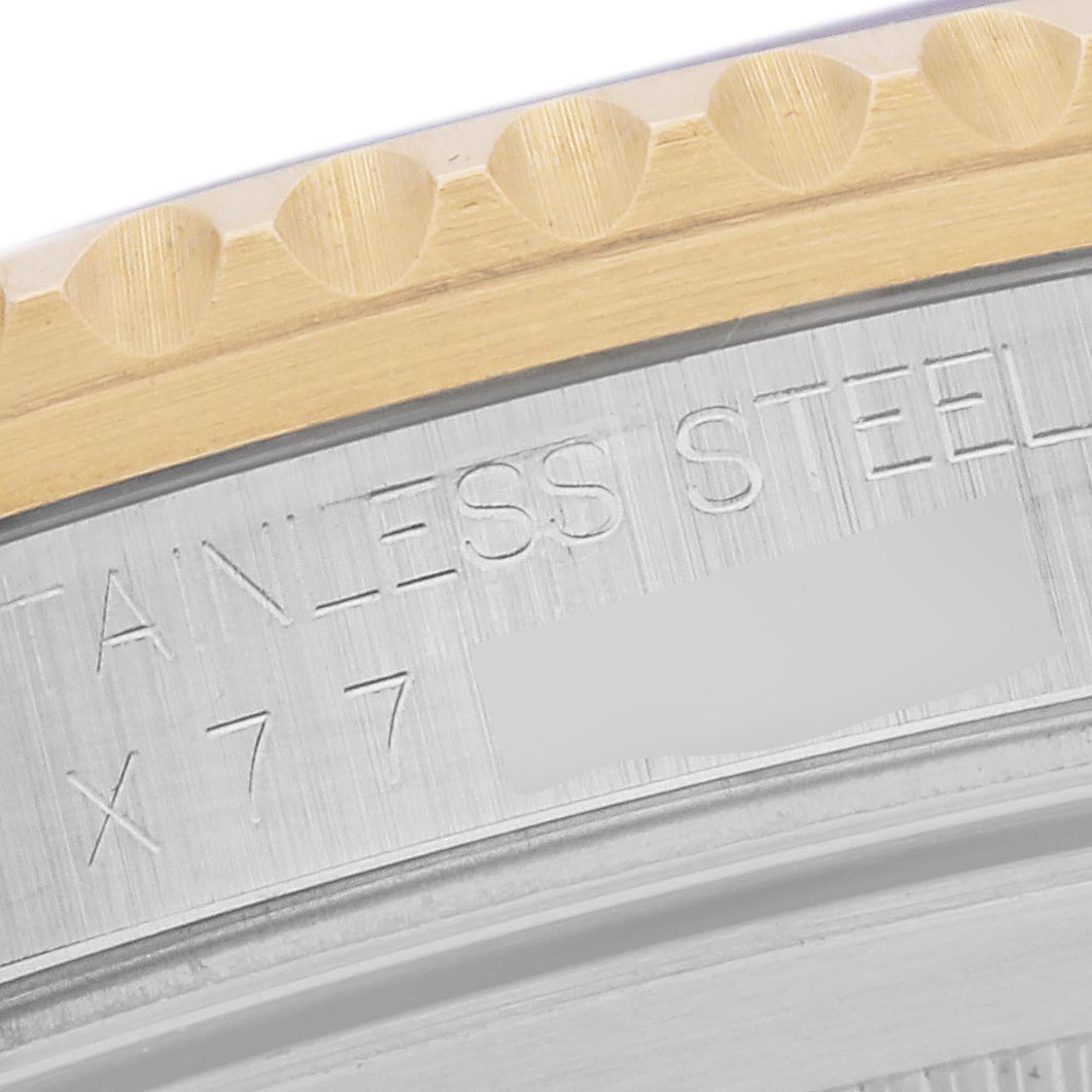 The image shows a close-up of the case side of a Rolex GMT-Master 16713LN Men
s Steel and Gold (two tone) Black Dial 16713LN Men
s Steel and Gold (two tone) Black Dial, featuring engraved text and part of the bezel.