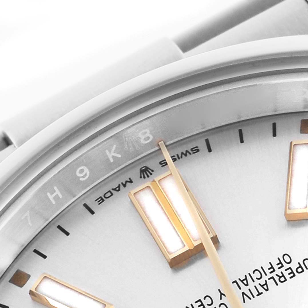 The image shows a close-up of the dial and bezel of a Rolex Oyster Perpetual 124300 Men's Stainless Steel Silver Dial 124300 Men's Stainless Steel Silver Dial, focusing on the hour markers and text.