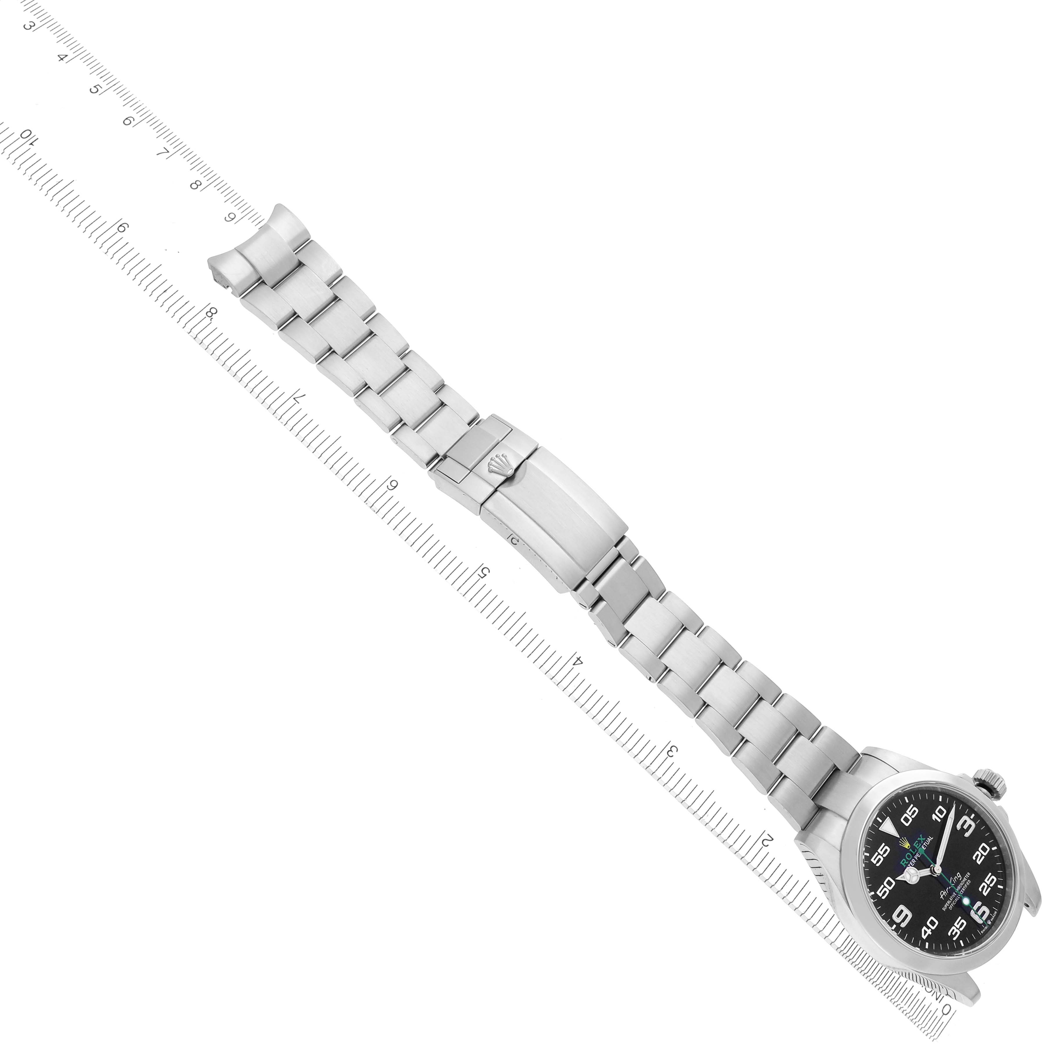The Rolex Air-King 126900 Men's Stainless Steel Black Dial 126900 Men's Stainless Steel Black Dial watch is shown at a diagonal angle, displaying the bracelet, clasp, and face alongside a ruler for scale.