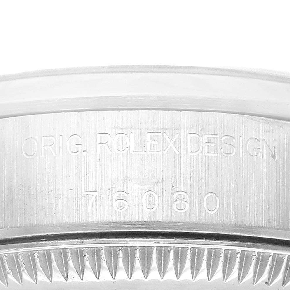 This image shows the side view of the bezel and casing of a Rolex Oyster Perpetual 76080 Women's Stainless Steel Black Dial 76080 Women's Stainless Steel Black Dial watch, highlighting the engravings.
