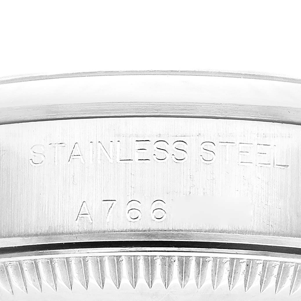 This is a close-up view of the side of the Rolex Oyster Perpetual 76080 Women's Stainless Steel Black Dial 76080 Women's Stainless Steel Black Dial watch showing the "STAINLESS STEEL" engraving and a portion of the watch's bezel.