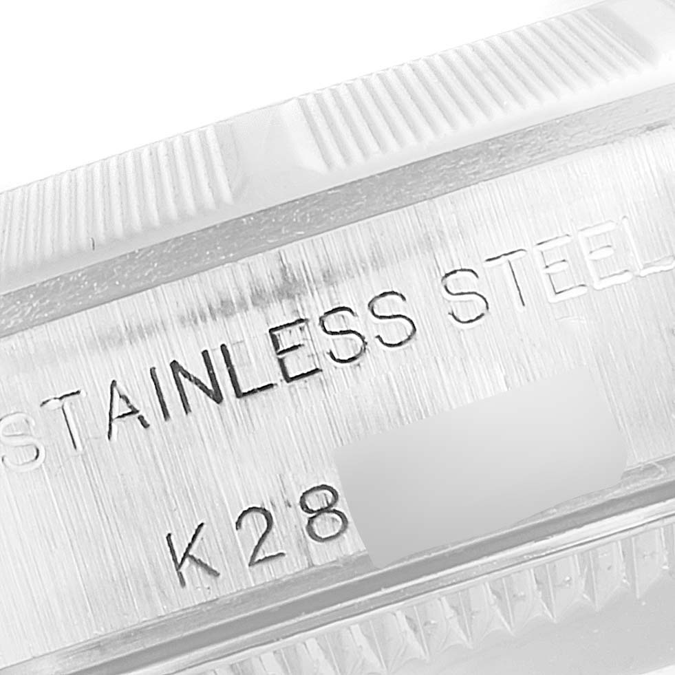 The image shows a close-up of the stainless steel case with engraved text from a Rolex Oyster Perpetual 76030 Women's Stainless Steel Pink Dial 76030 Women's Stainless Steel Pink Dial watch.