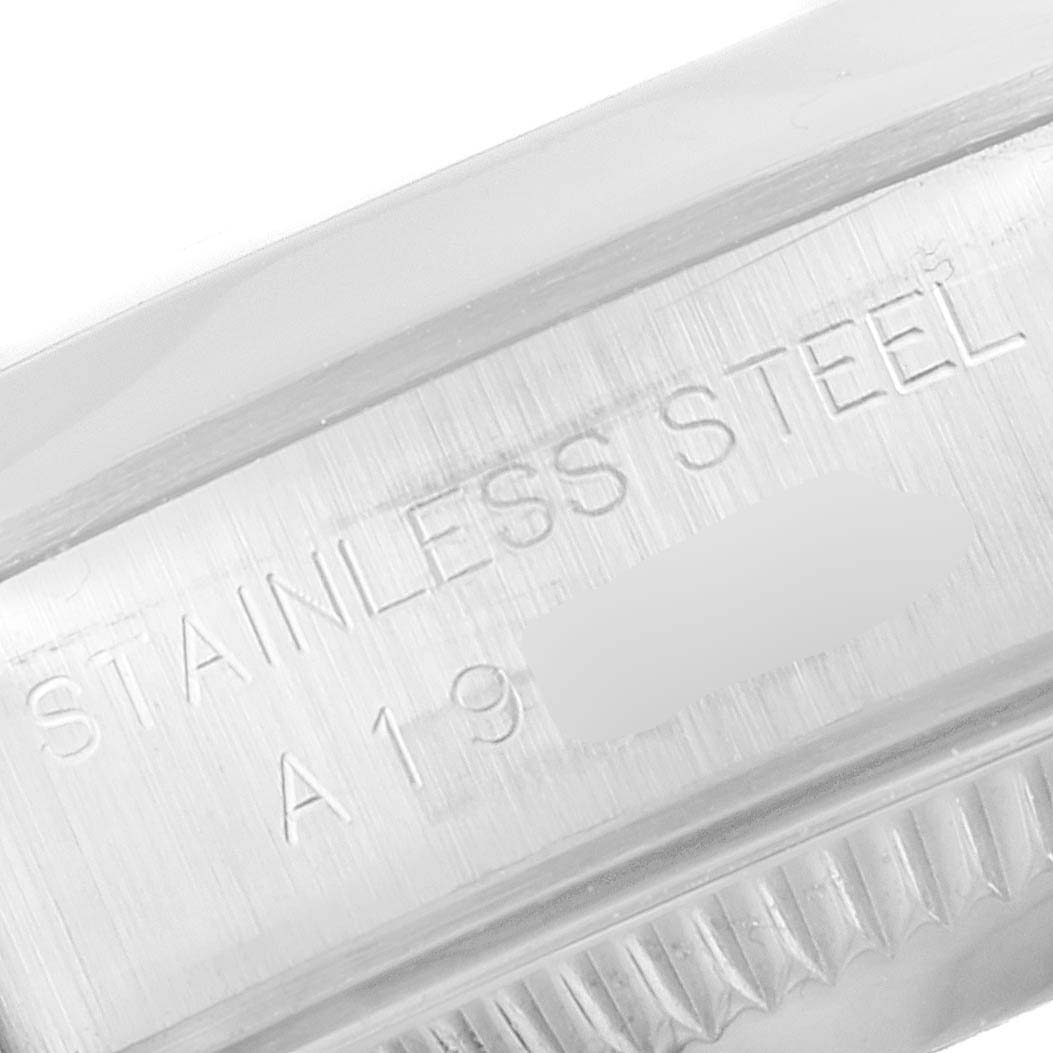 The image shows a close-up of the stainless steel casing and part of the crown of a Rolex Oyster Perpetual 76080 Women's Stainless Steel Pink Dial 76080 Women's Stainless Steel Pink Dial watch.