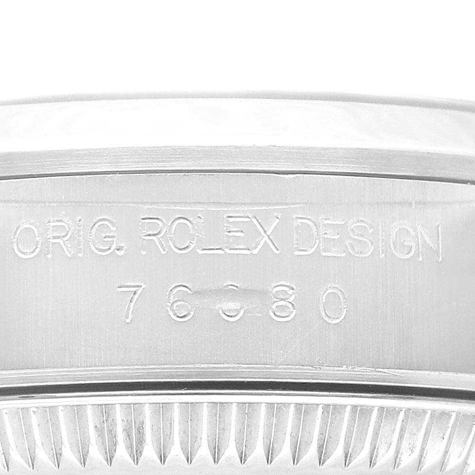 The image shows a close-up of the case's side, highlighting the engraved "ORIG. ROLEX DESIGN" and model number on a Rolex Oyster Perpetual 76080 Women's Stainless Steel Pink Dial 76080 Women's Stainless Steel Pink Dial.