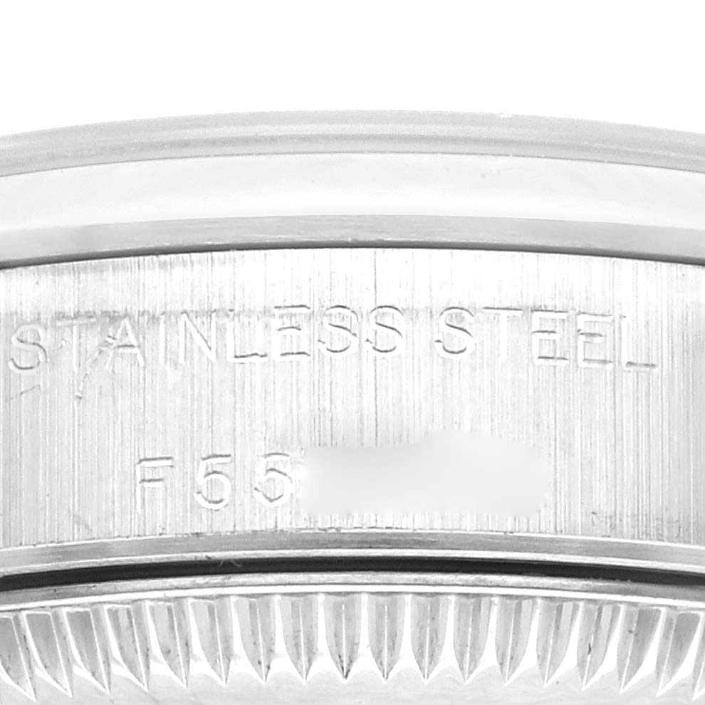 This image shows a close-up of the side of a stainless steel case of a Rolex Oyster Perpetual 76080 Women's Stainless Steel Pink Dial 76080 Women's Stainless Steel Pink Dial watch with stamped engravings.
