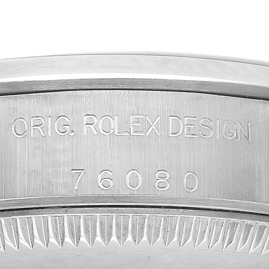 The image shows a close-up of the edge and engraving on the bezel of a Rolex Oyster Perpetual 76080 Women's Stainless Steel White Dial 76080 Women's Stainless Steel White Dial watch.
