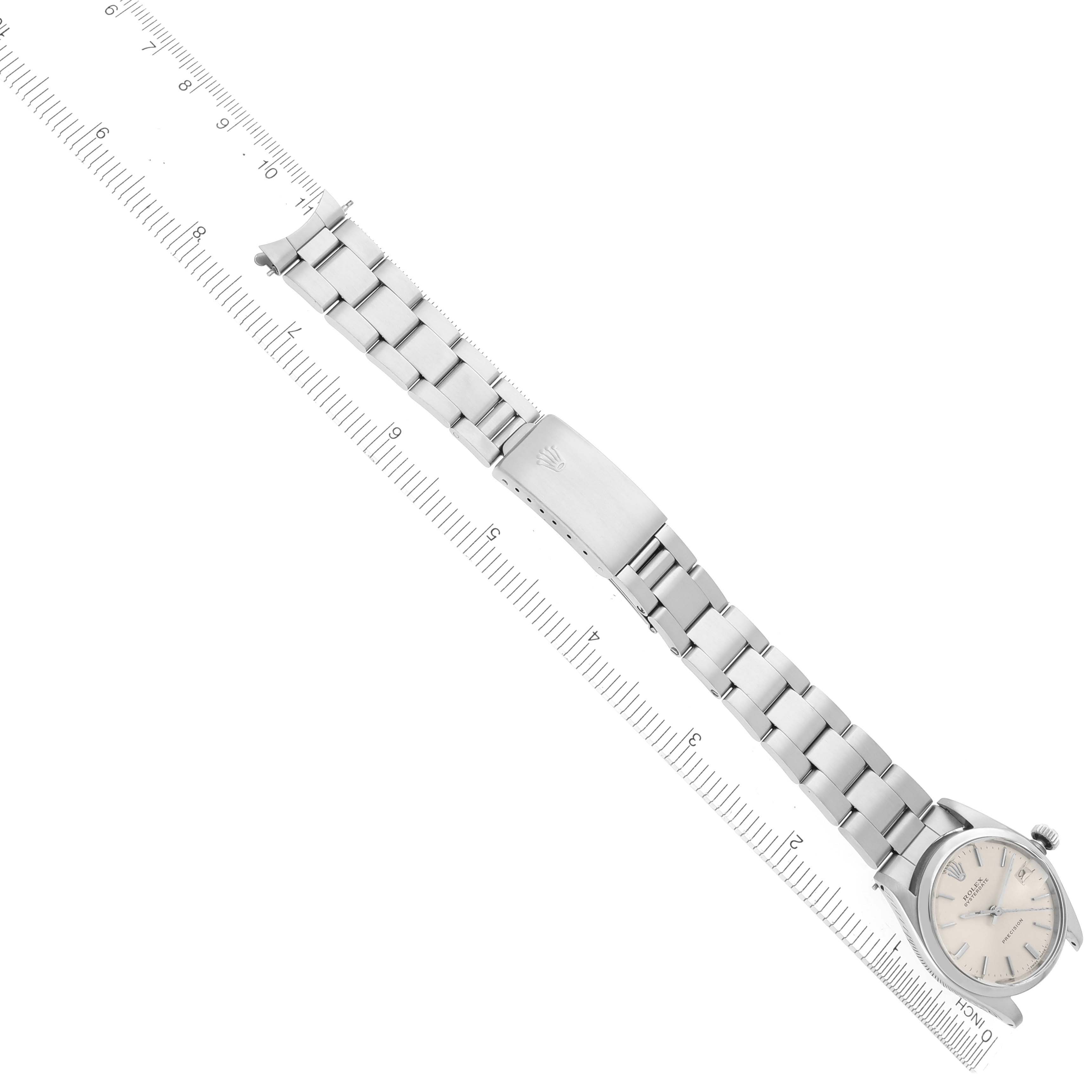 The image shows a side angle of a Rolex Date 6466 Women's Stainless Steel Silver Dial 6466 Women's Stainless Steel Silver Dial watch with its full metal bracelet and clasp visible alongside a ruler.