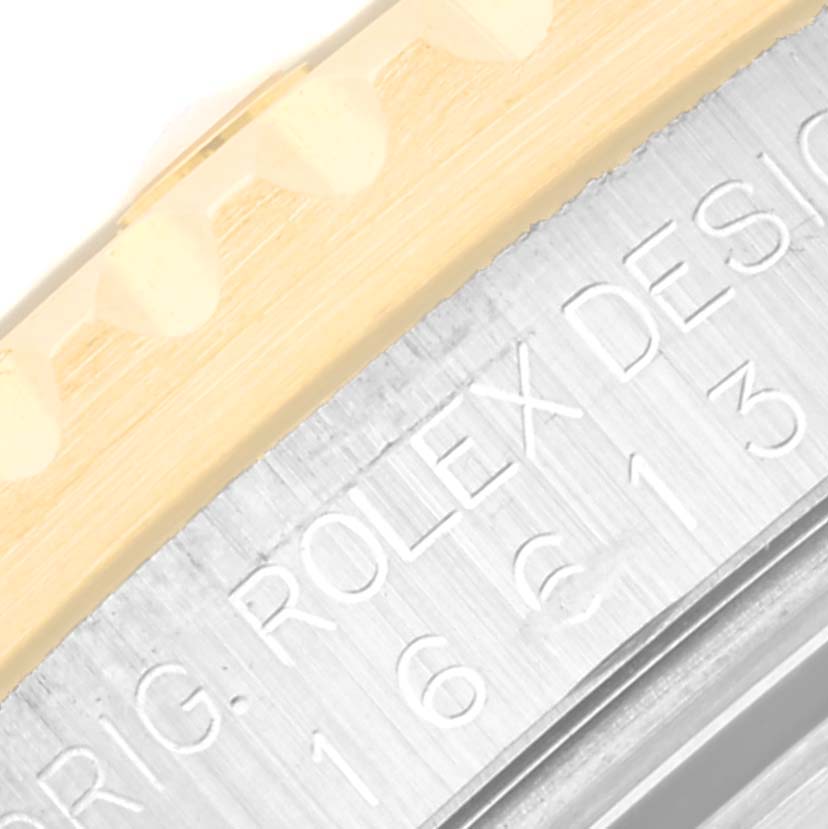 The image shows a close-up of the Submariner Rolex model's bezel and engraved watch case.