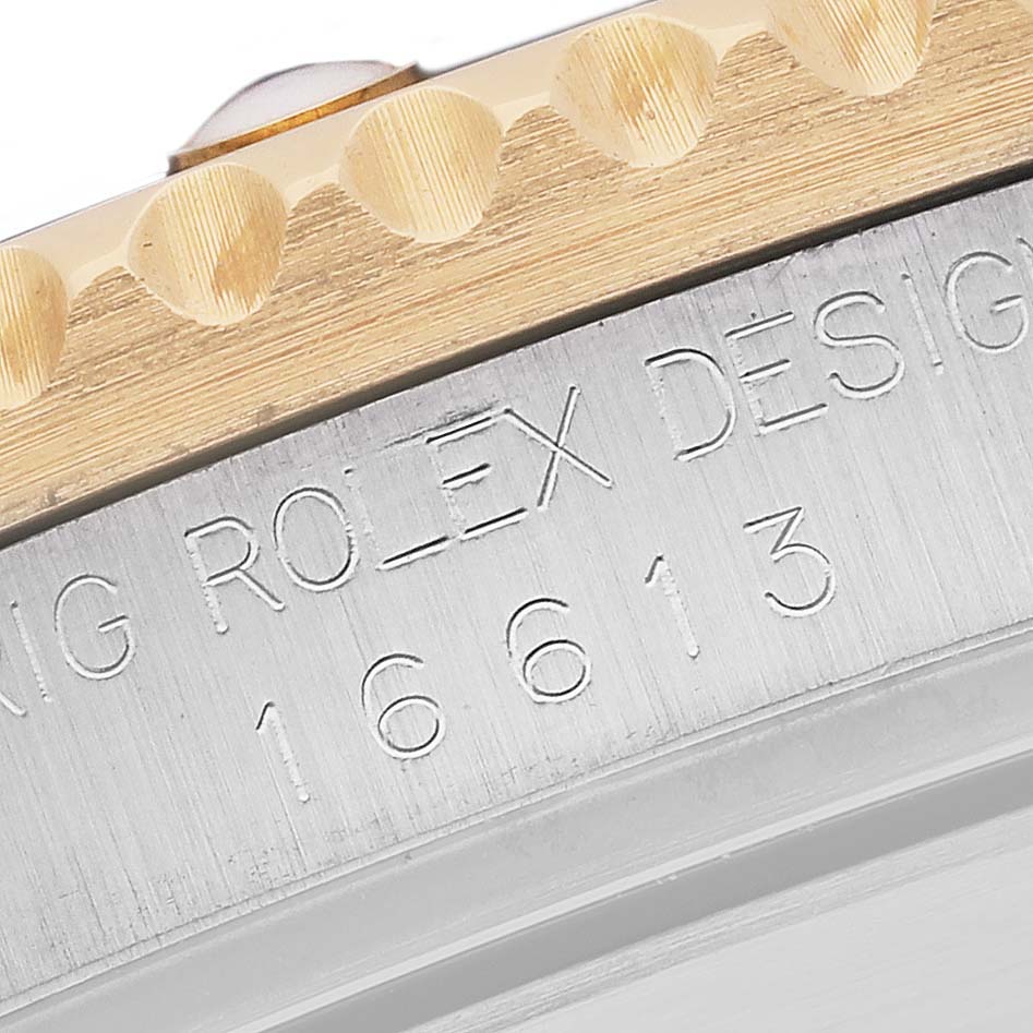 The image shows a close-up of the side, bezel, and engraved model number of a Rolex Submariner 16613 Men's Steel and Gold (two tone) Blue Dial 16613 Men's Steel and Gold (two tone) Blue Dial watch.