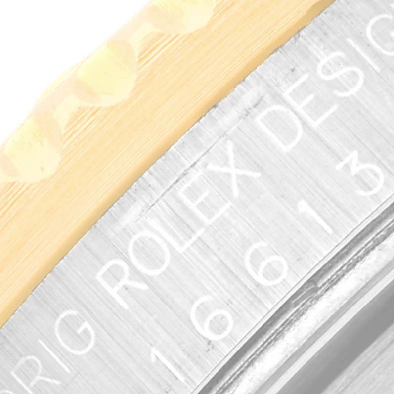 This close-up image shows the side of a Rolex Submariner 16613 Men's Steel and Gold (two tone) Blue Dial 16613 Men's Steel and Gold (two tone) Blue Dial watch, highlighting the bezel and engraved text on the case.