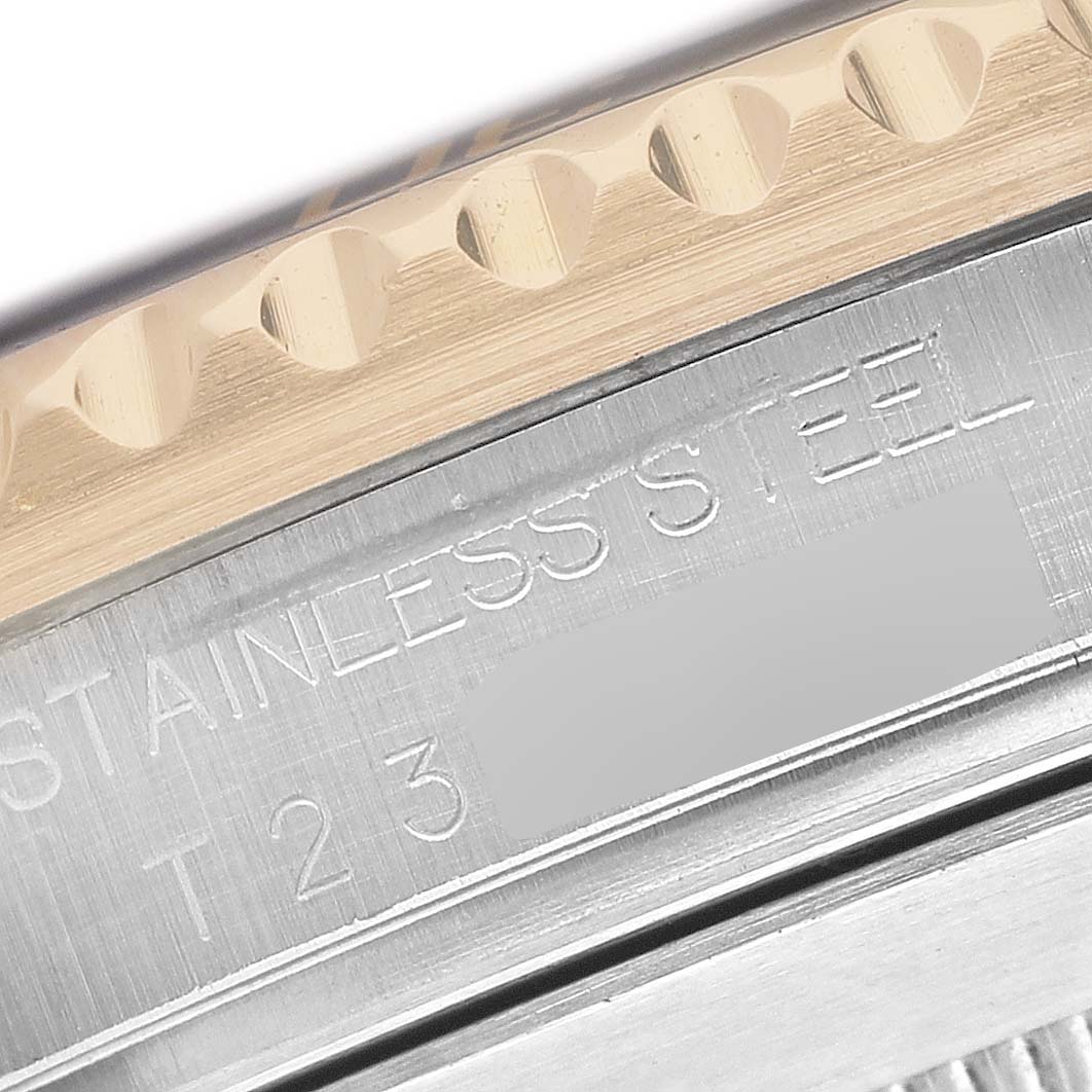 The image shows a close-up of the bezel and engraved details on a Rolex Submariner 16613 Men's Steel and Gold (two tone) Black Dial's stainless steel case.