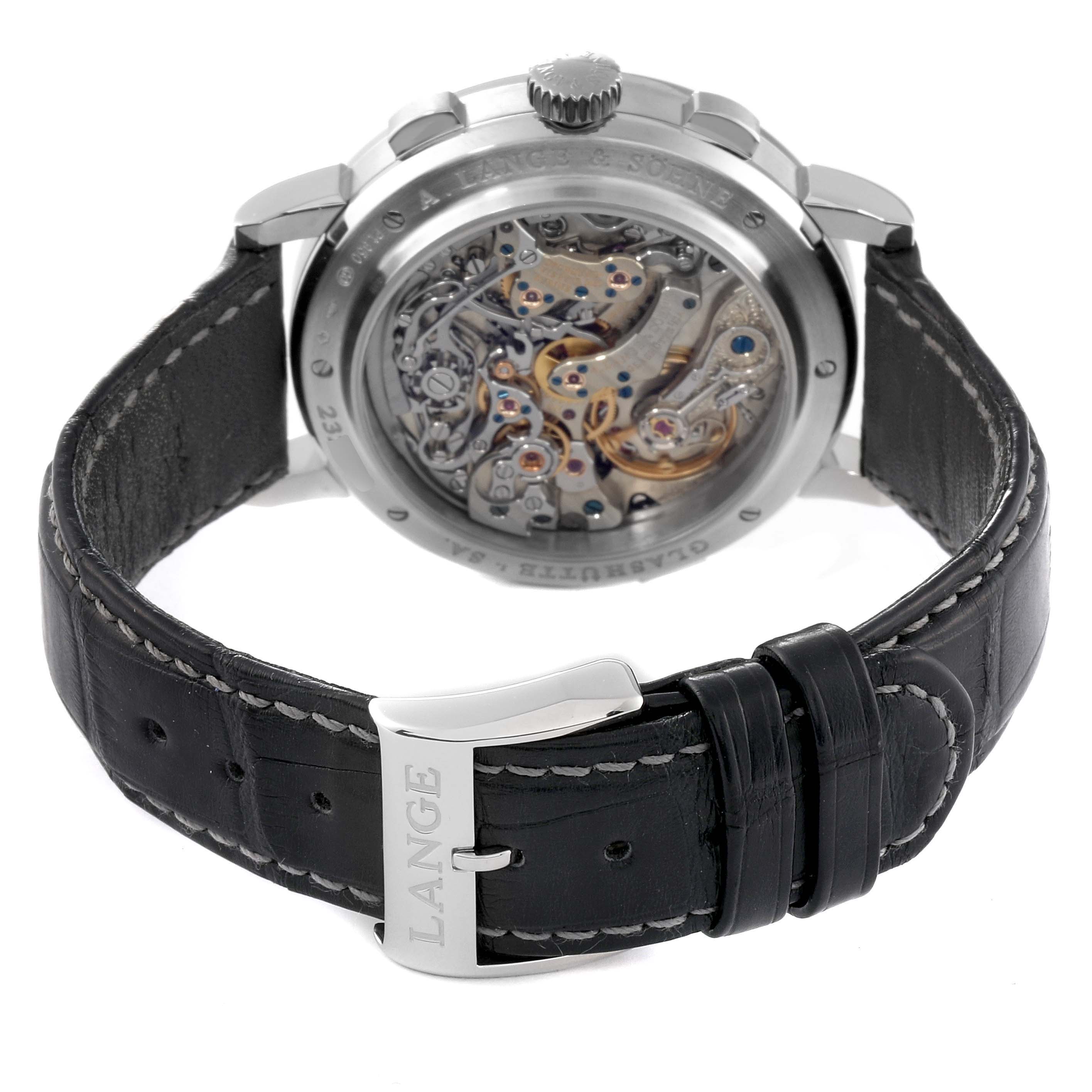 This image shows the back view of the A. Lange 
Sohne Datograph 405.035 Men
s Platinum Black Dial, displaying its intricate movement and leather strap with "LANGE" engraved on the clasp.