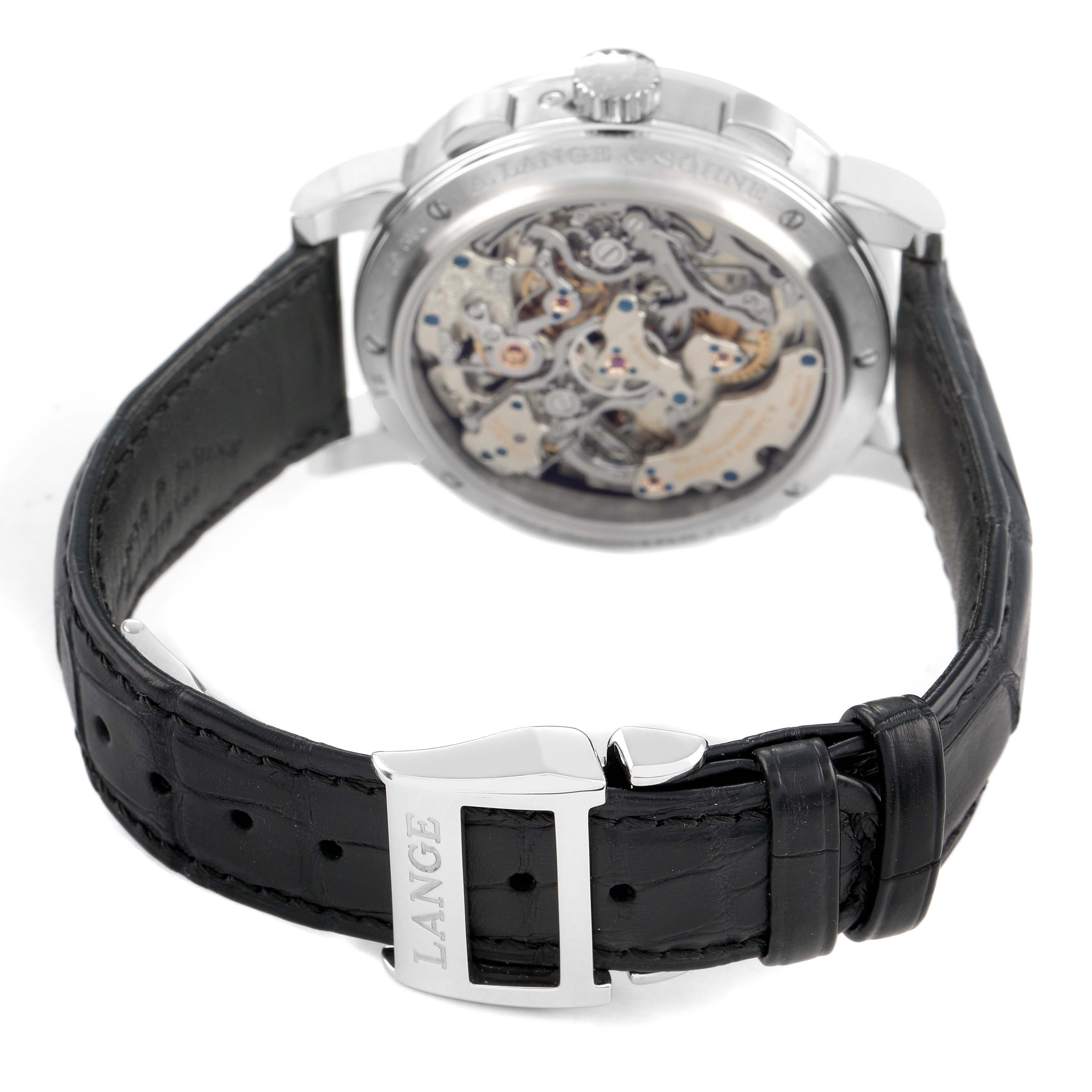 The image shows the back and side of the A. Lange & Sohne 1815 421.025FE Men's Platinum Silver Dial watch, displaying its intricate movement and leather strap with a buckle.