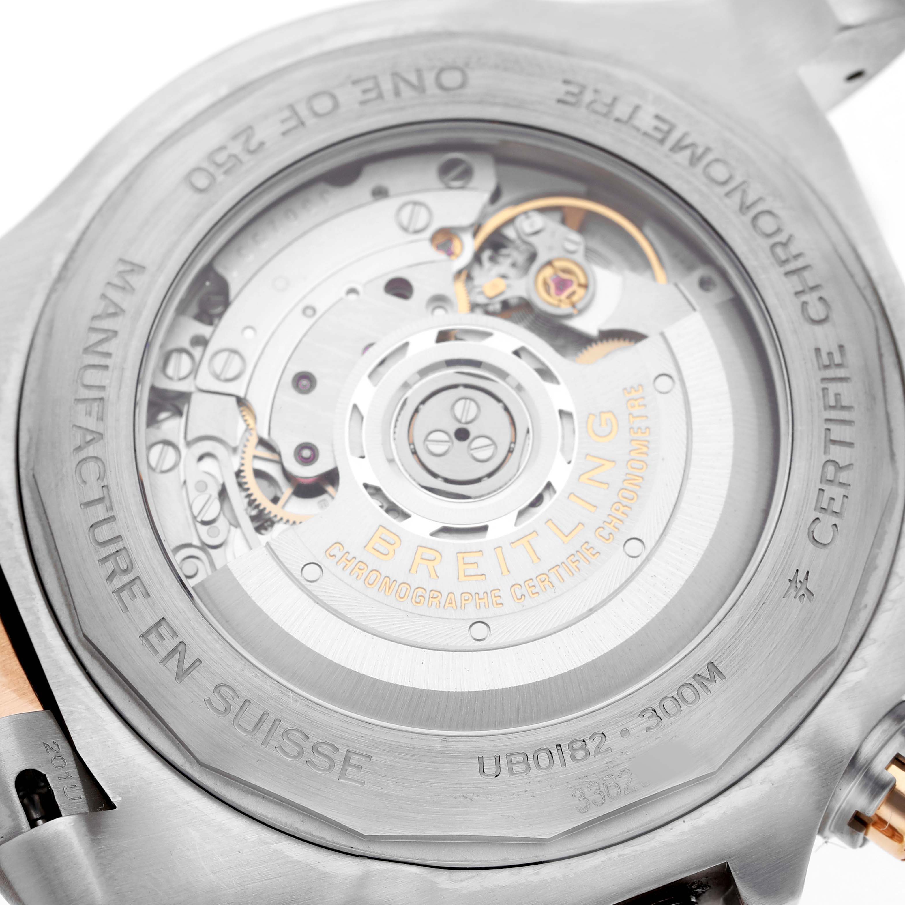 The image shows the back view of the Breitling Avenger UB01821A1B1U1 Men's Steel and Gold (two tone) Grey Dial watch, highlighting its movement and engravings.