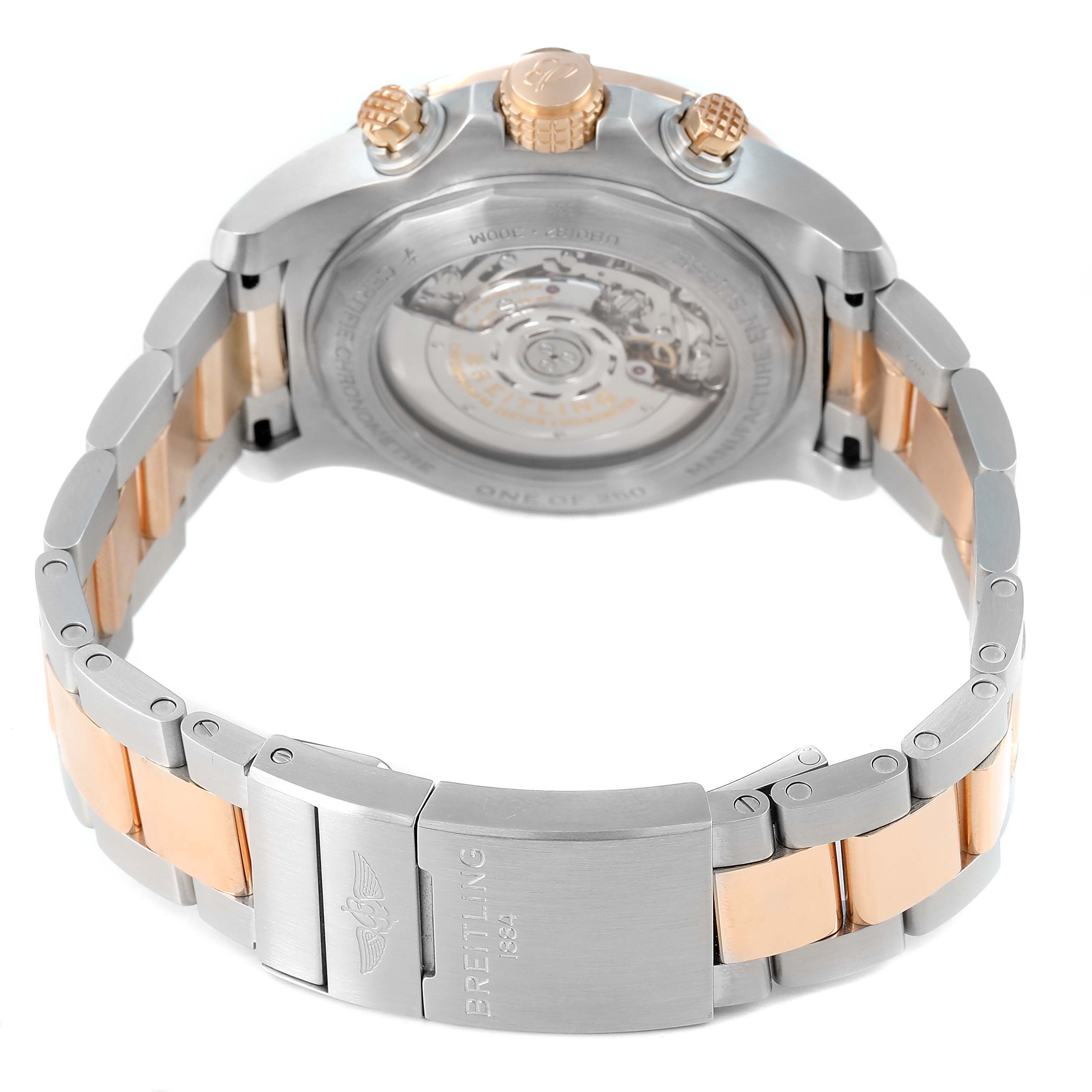 The image shows the back view of a Breitling Avenger UB01821A1B1U1 Men's Steel and Gold (two tone) Grey Dial watch with a transparent case back and a two-tone bracelet.