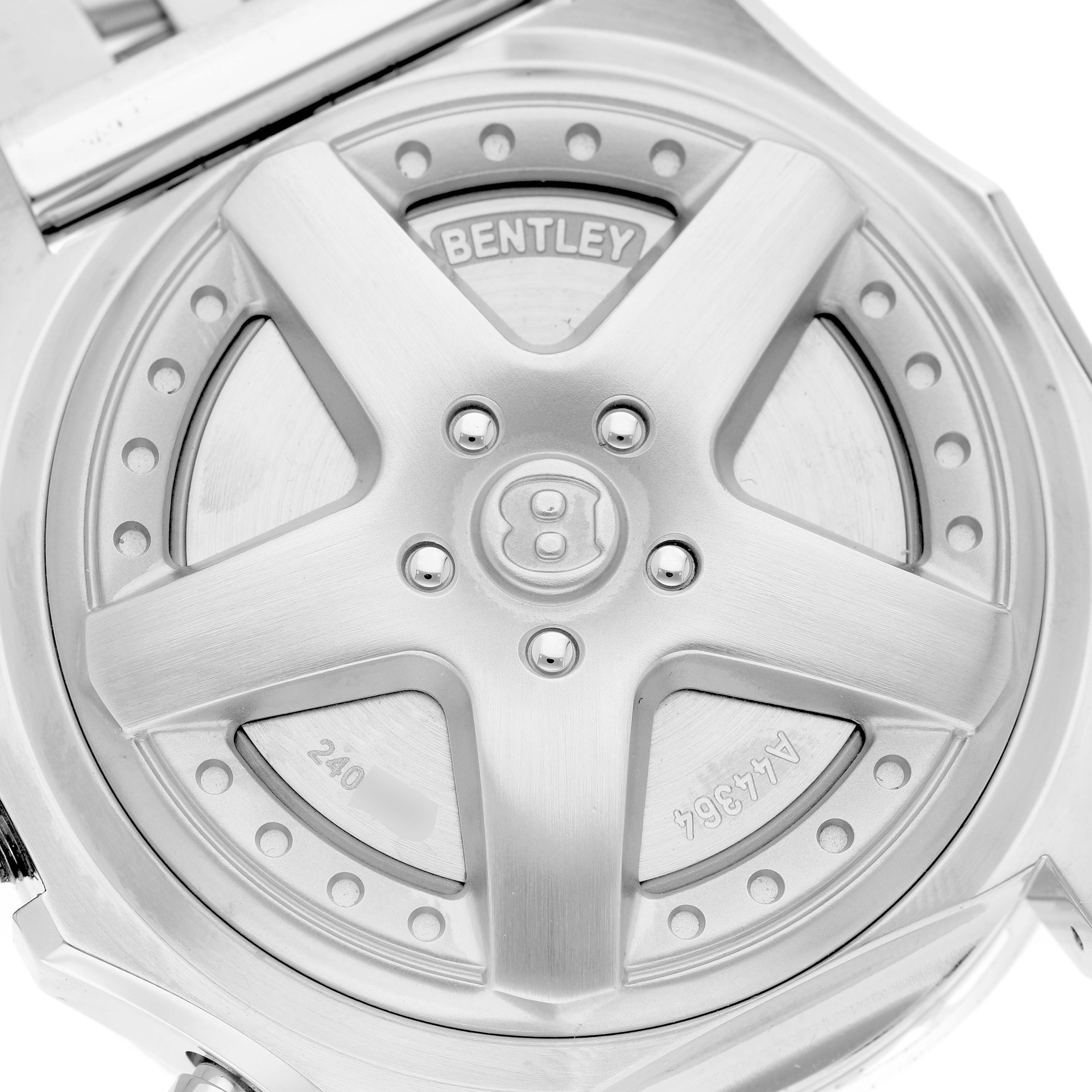 The image shows the back casing of a Bentley model watch by Breitling, featuring a wheel-inspired design with engraved details.