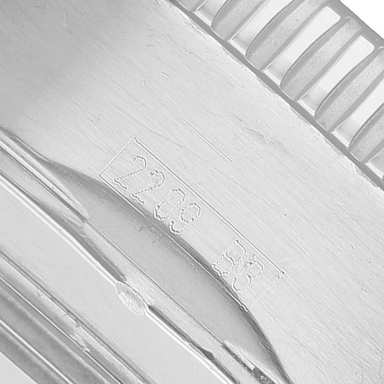 The image shows a close-up of the engraved edge and bezel teeth of a Breitling Superocean A23320 Men's Stainless Steel Silver Dial watch band.