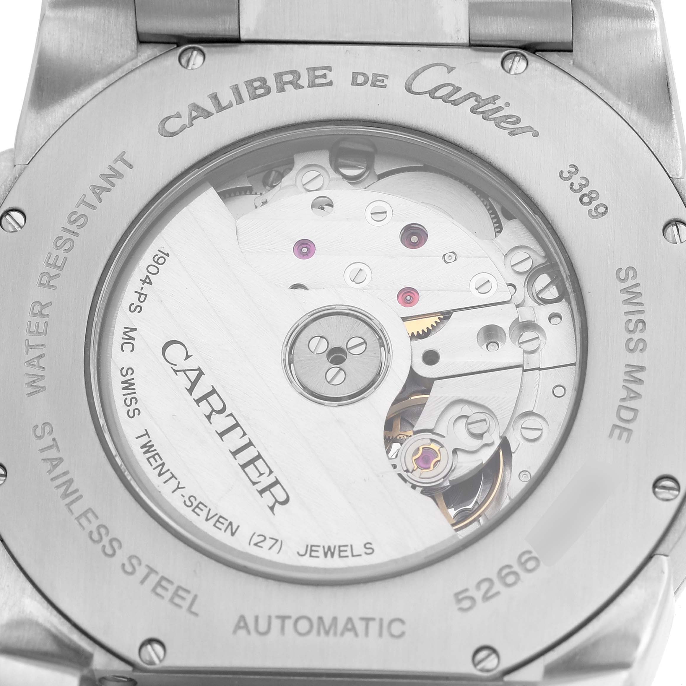 The image shows the back view of the Calibre de Cartier watch, highlighting its automatic movement and internal mechanics.