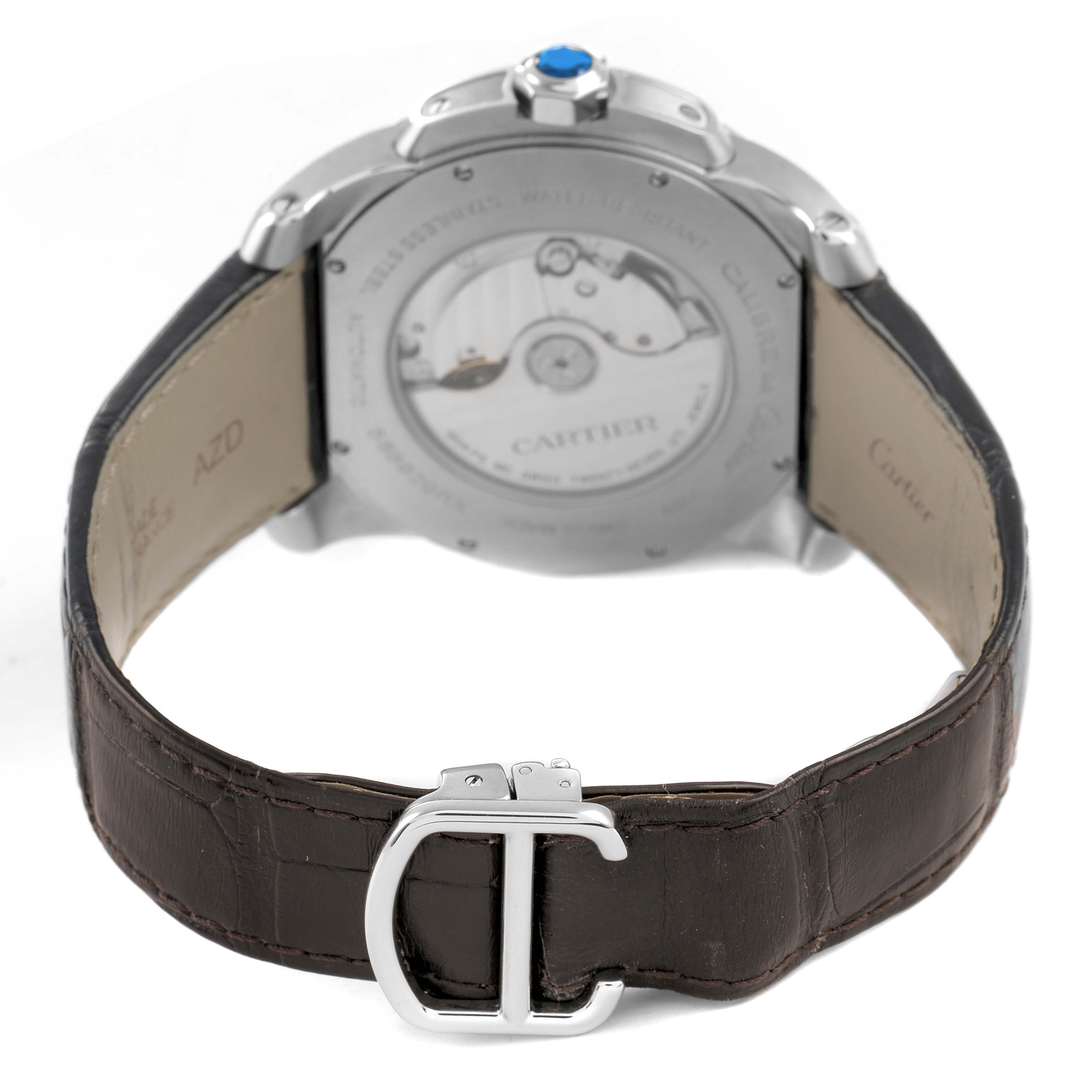 The image shows the back of a Calibre de Cartier watch by Cartier, displaying the movement, strap, and buckle.