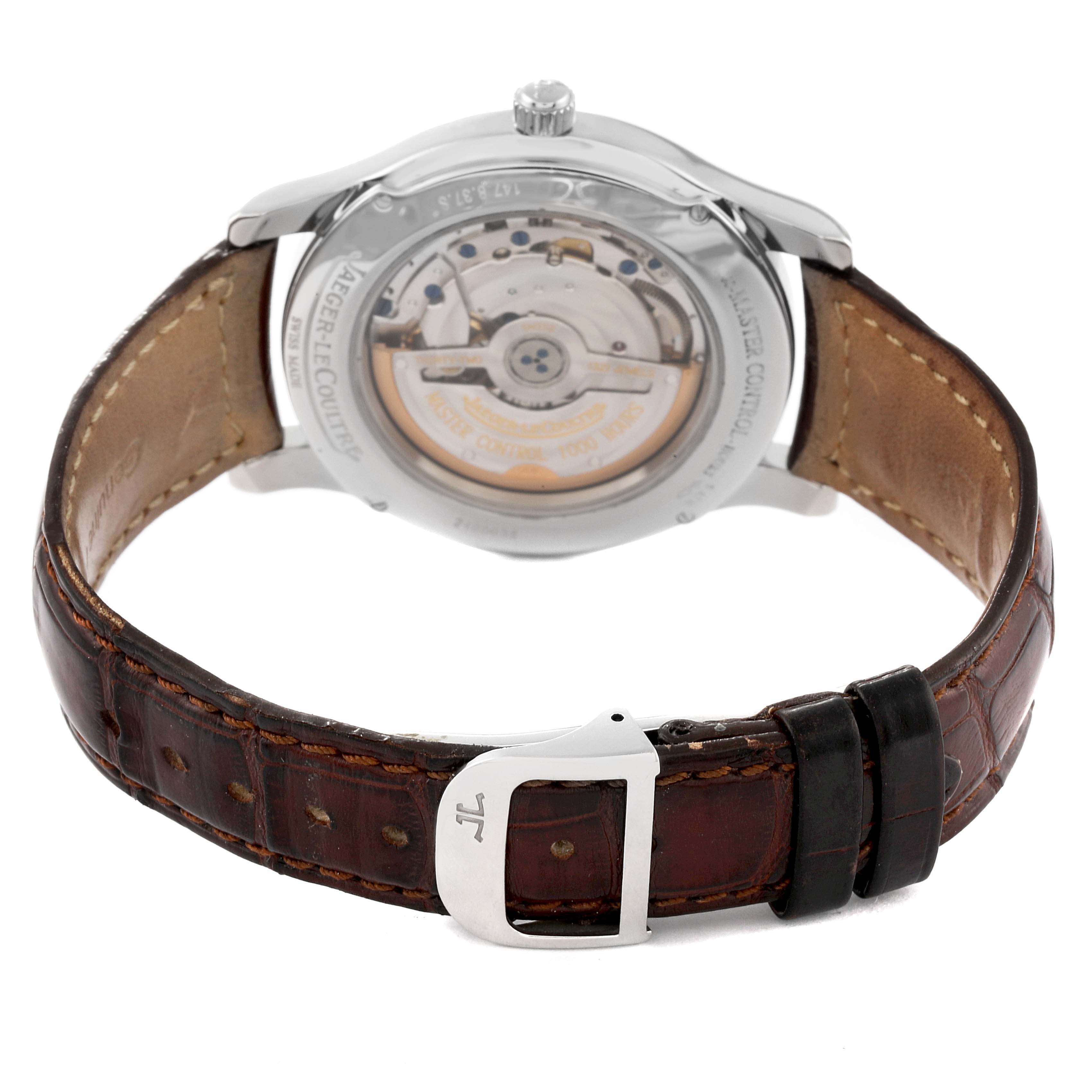 The Jaeger-LeCoultre Master model watch is shown from the back, displaying the rotor and movement with a leather strap and buckle.