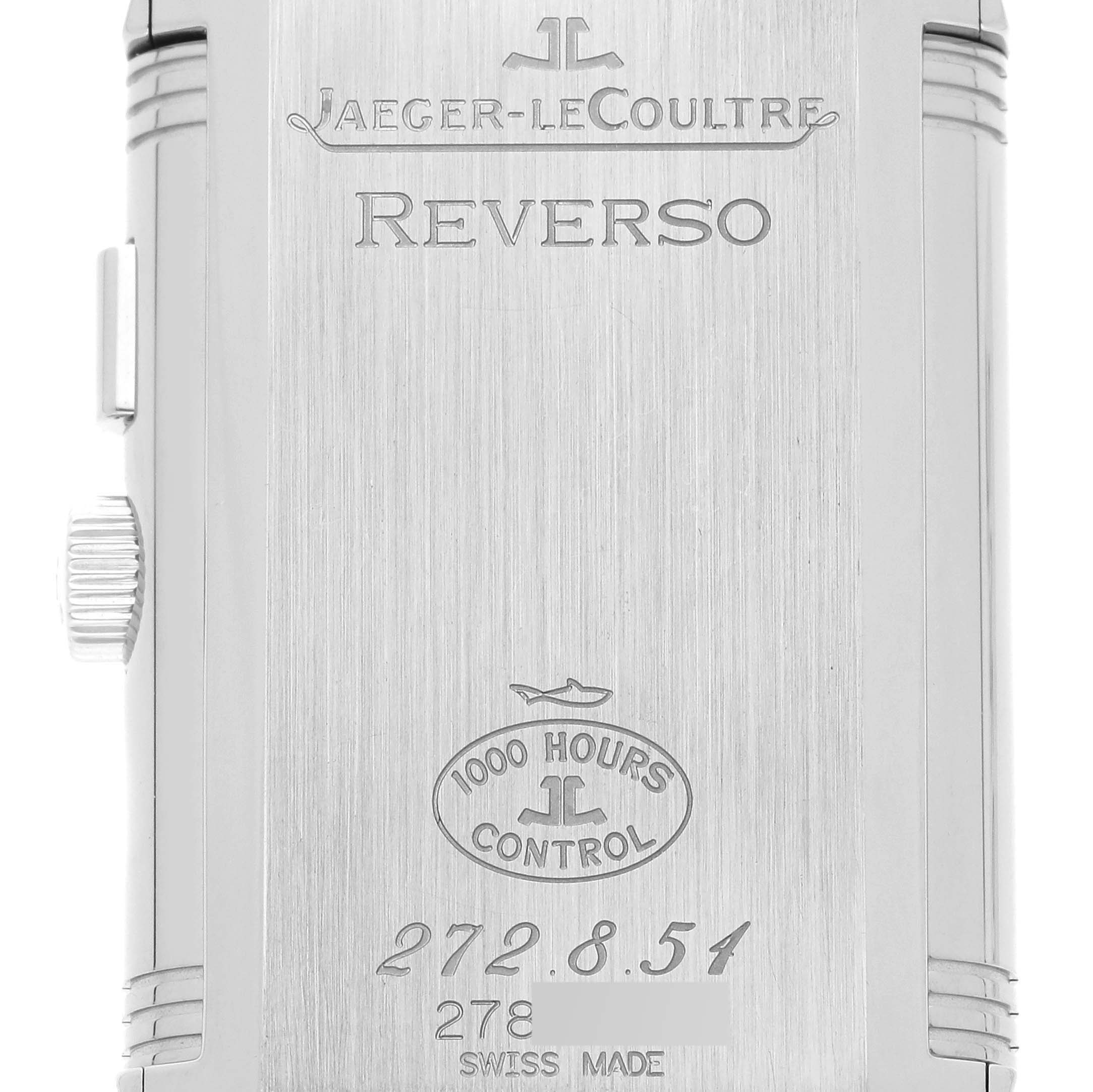 The image shows the back of a Jaeger-LeCoultre Reverso watch case, featuring the brand, model name, and various engravings.