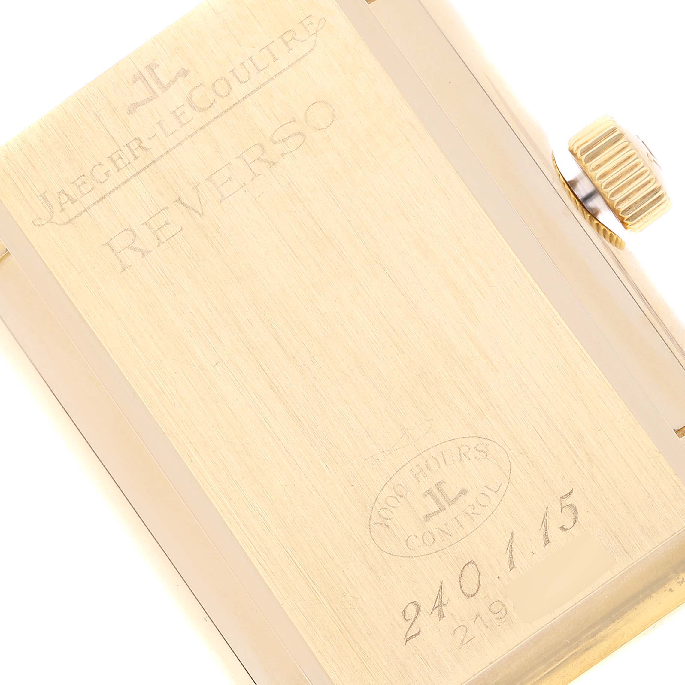 The image shows the back of a Jaeger-LeCoultre Reverso watch, showcasing the engraved details and the crown on the side.