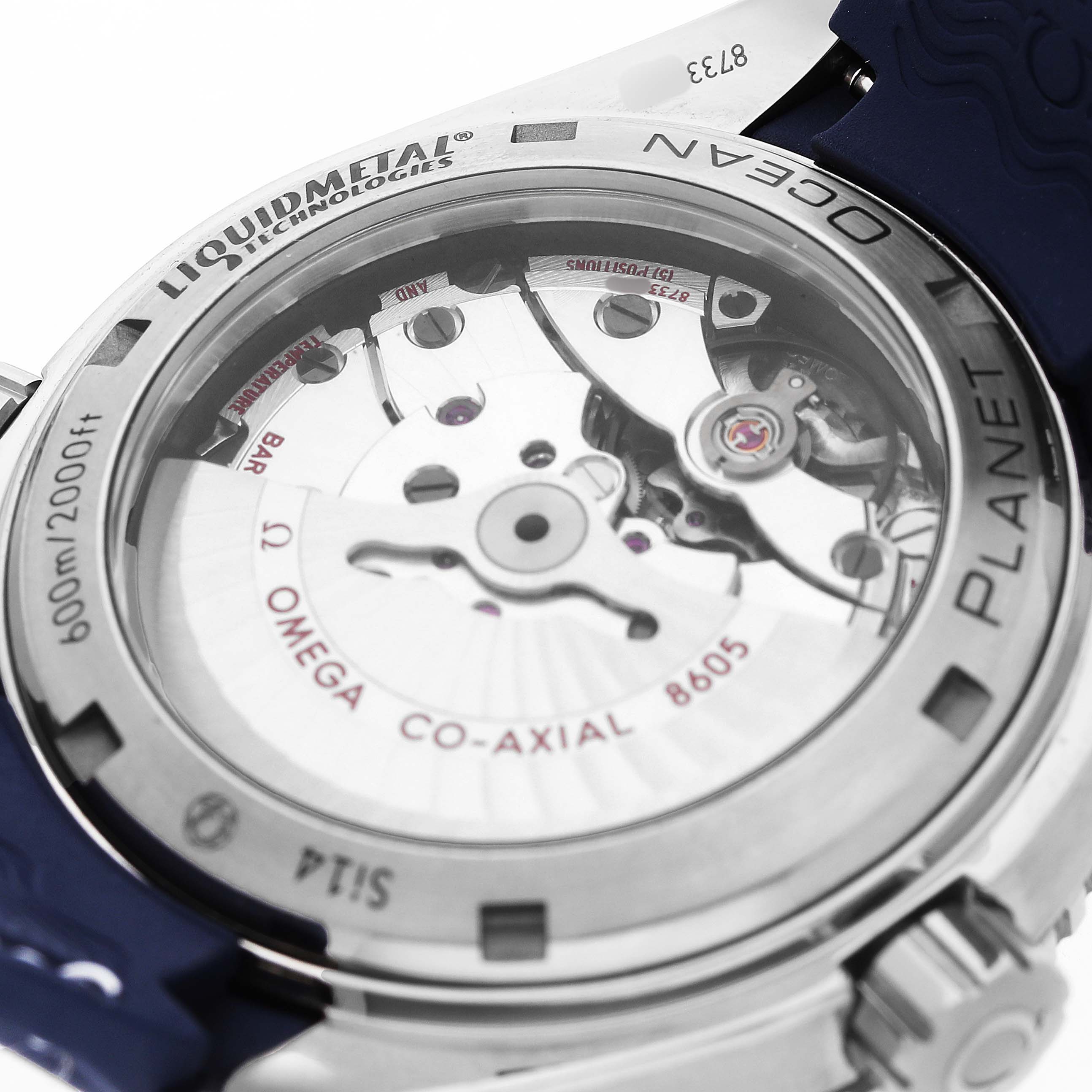 The image shows the back of the Omega Planet Ocean 232.92.44.22.03.001 Men's Titanium Blue Dial watch, revealing its movement and "Liquidmetal" bezel.