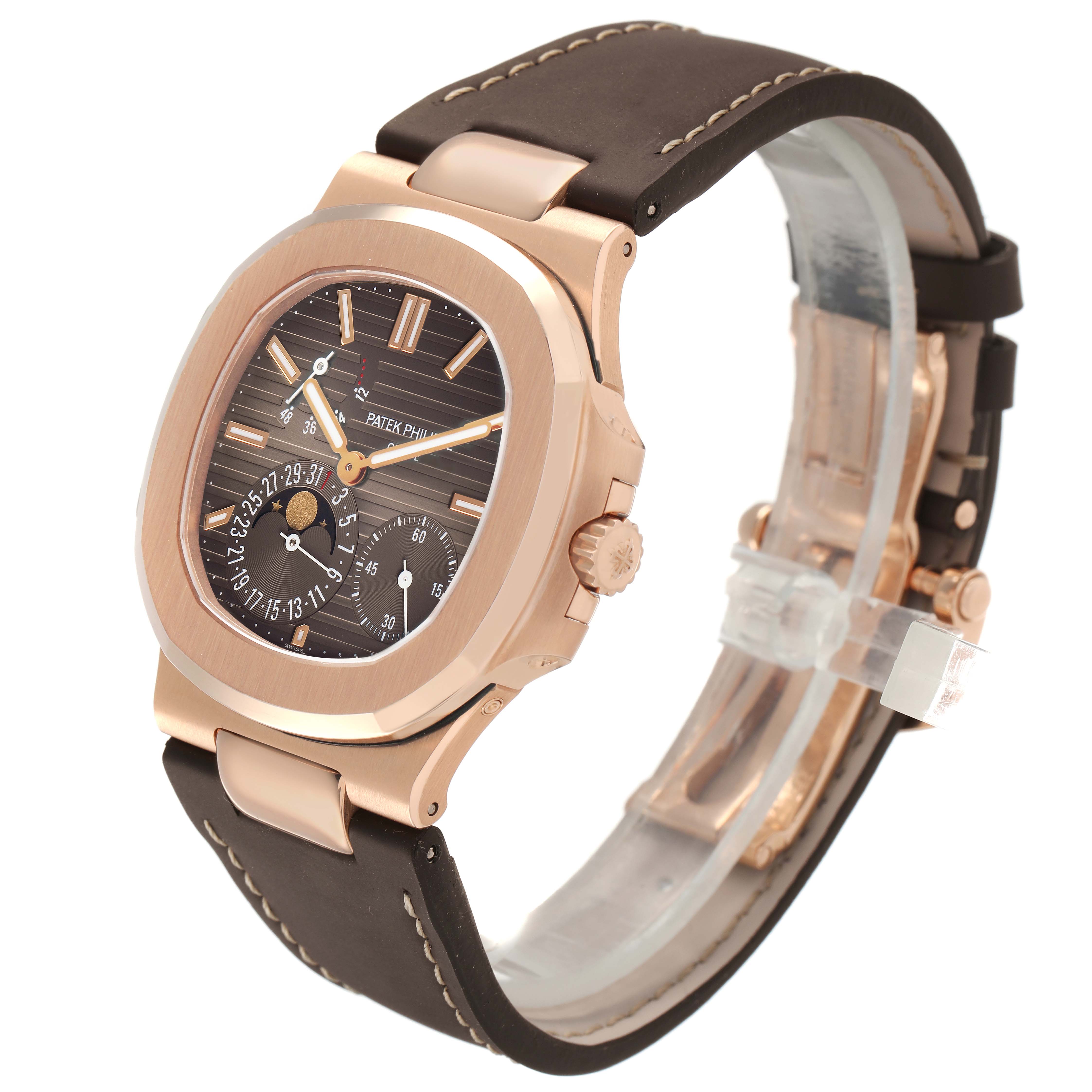 The Patek Philippe Nautilus 5712R-001 Men's Rose Gold Brown Dial watch is shown at a three-quarter angle, highlighting its face, bezel, crown, and leather strap.