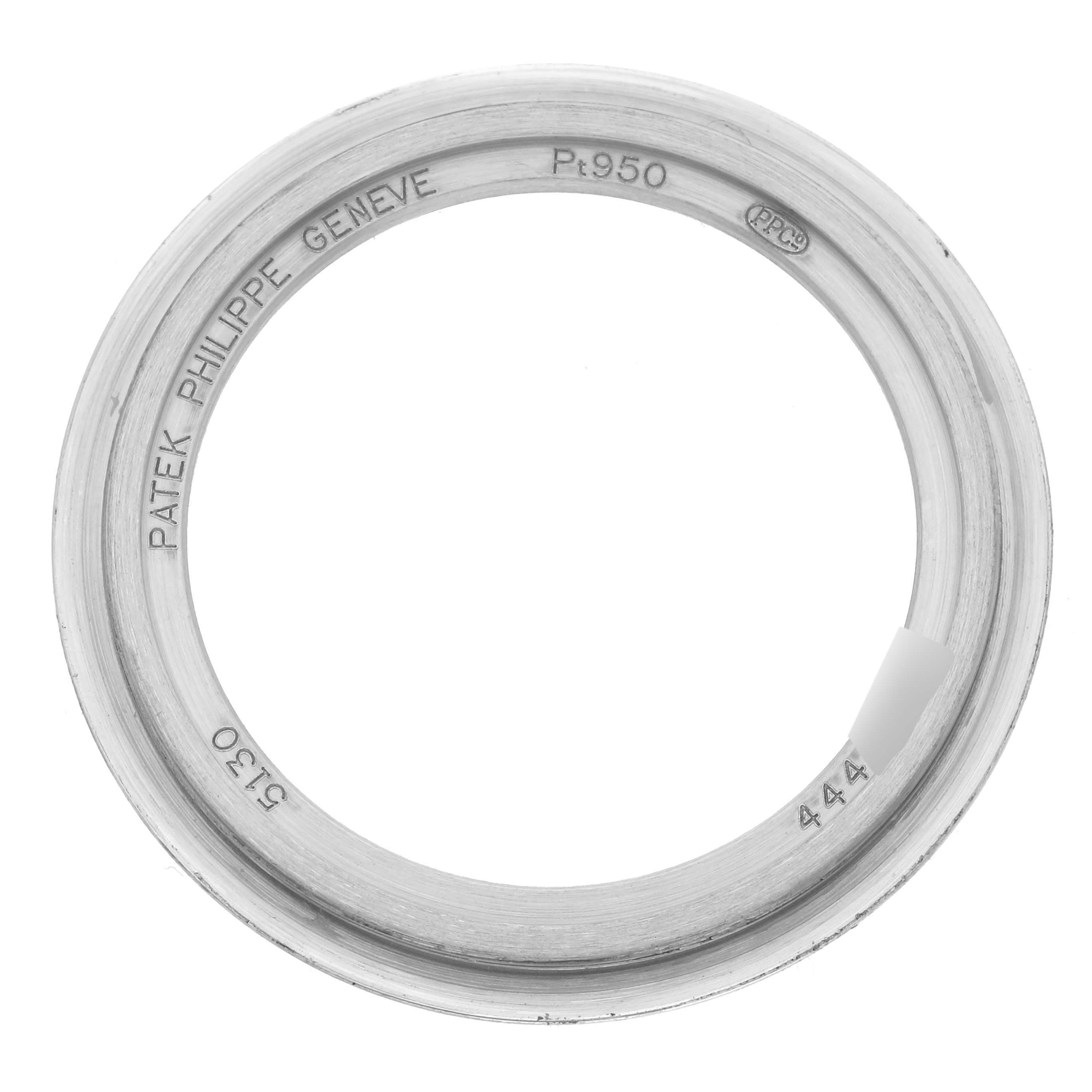 The image shows a Patek Philippe Complications 5130P-001 Men's Platinum Silver Dial 5130P-001 Men's Platinum Silver Dial watch bezel, viewed from above, highlighting engravings and the platinum material.