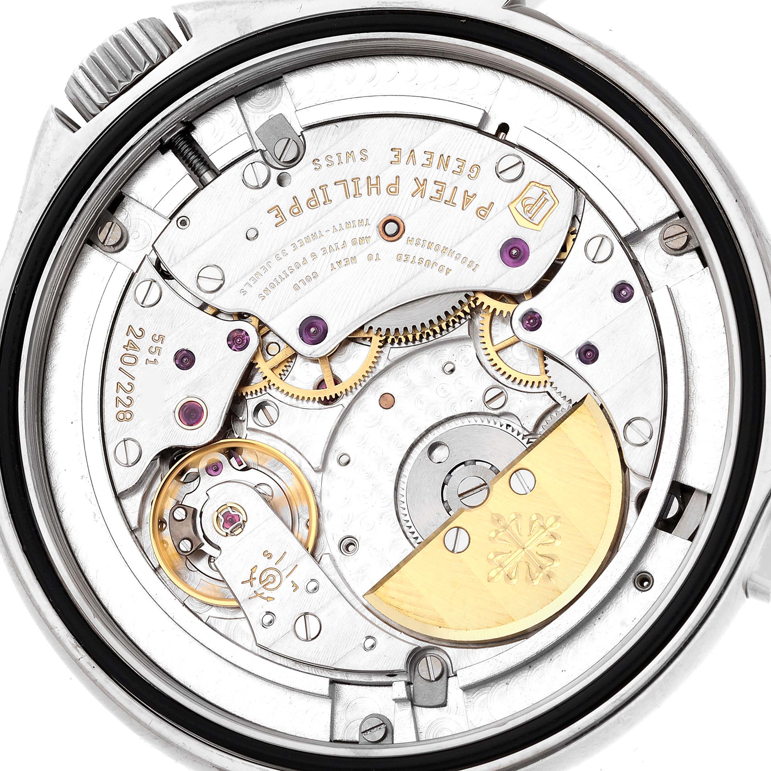 The image shows the back view of the movement mechanism in a Patek Philippe Complications 5130G-001 Men
s White Gold Silver Dial 5130G-001 Men
s White Gold Silver Dial watch, highlighting gears and inscriptions.