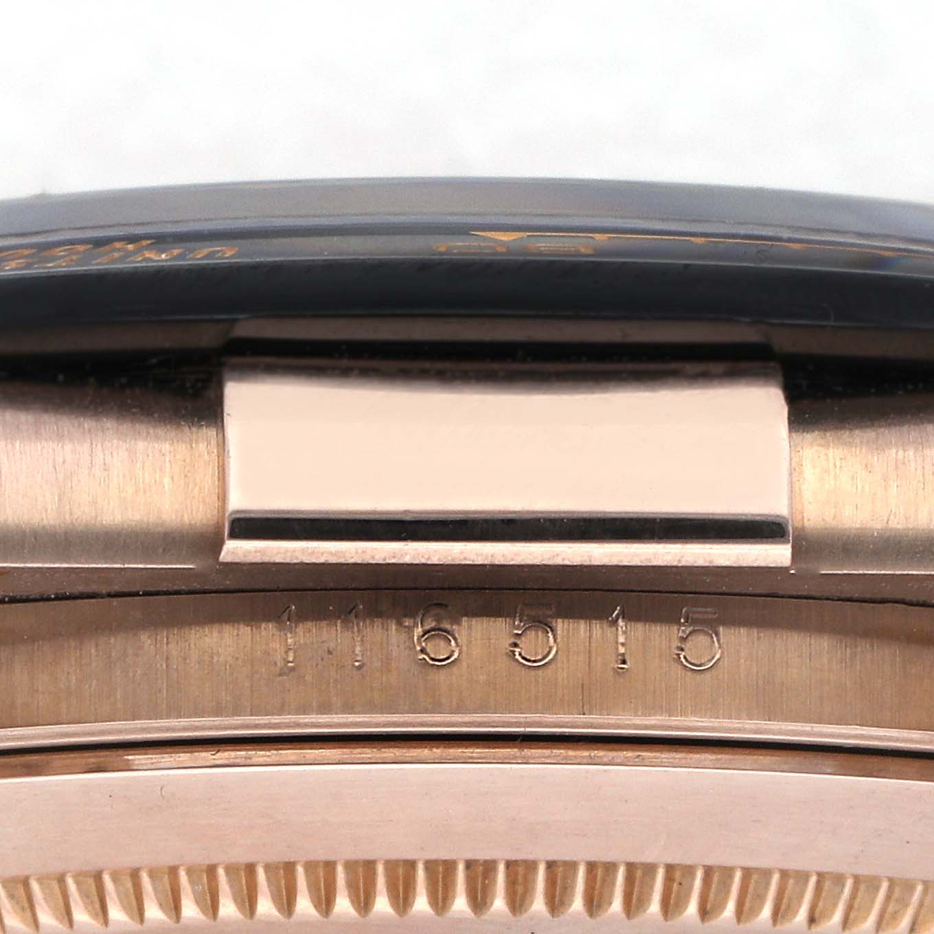 The image shows a close-up side view of a Rolex Daytona 116515LN Men's Rose Gold Pink Dial 116515LN Men's Rose Gold Pink Dial model, focusing on the case edge and engraved numbers.