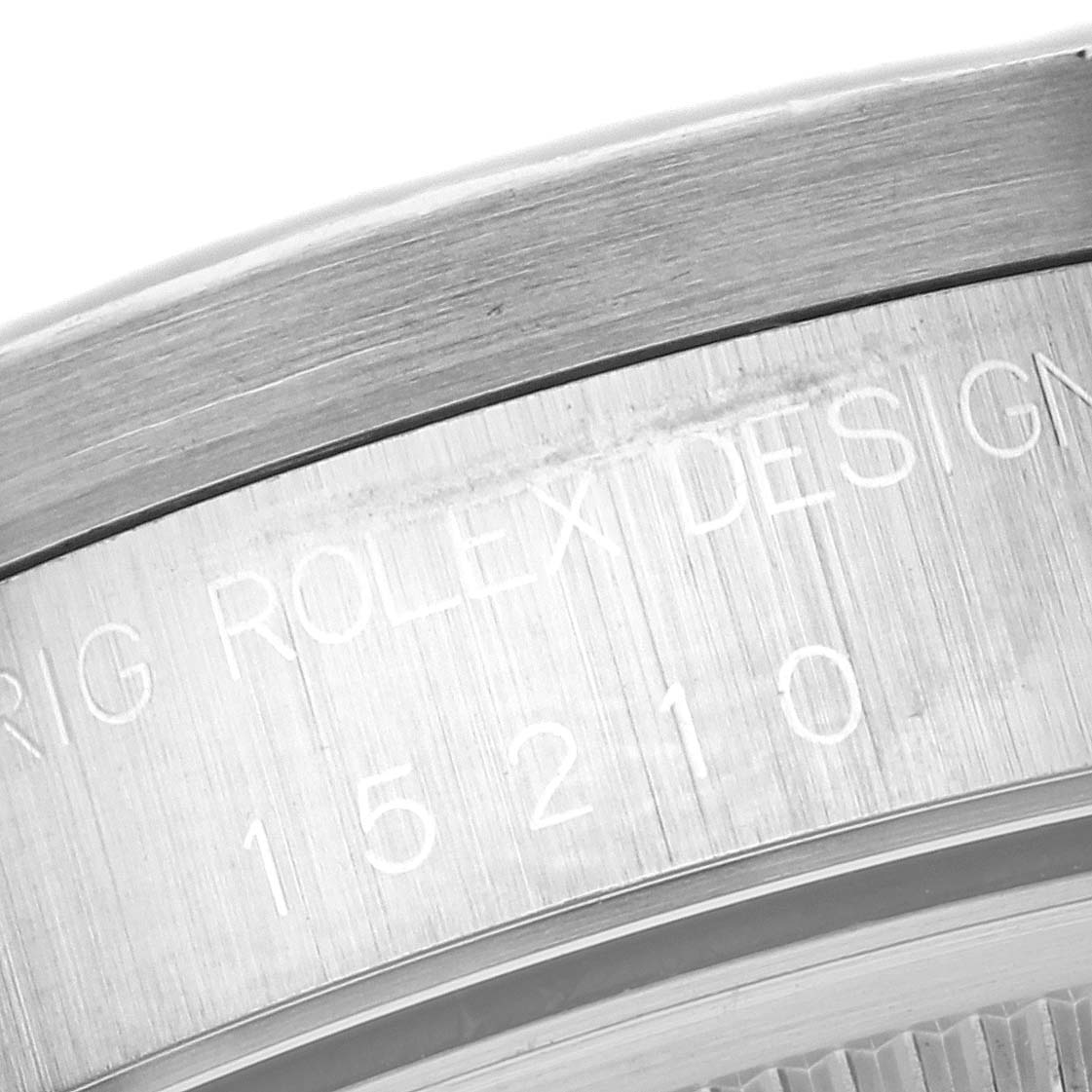 The image shows a close-up of the engraved design and model number on the side of a Rolex Date 15210 Men's Stainless Steel Blue Dial 15210 Men's Stainless Steel Blue Dial watch.