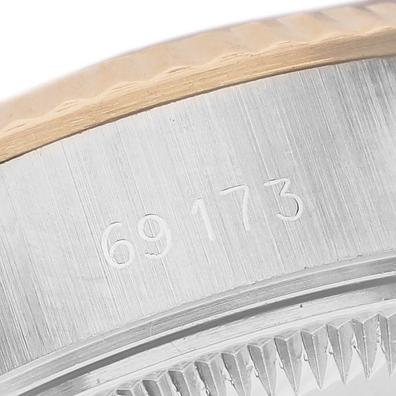 The image shows a close-up of the Rolex Datejust 69173 Women's Steel and Gold (two tone) Champagne Dial's side, focusing on the serial number and the fluted bezel edge.