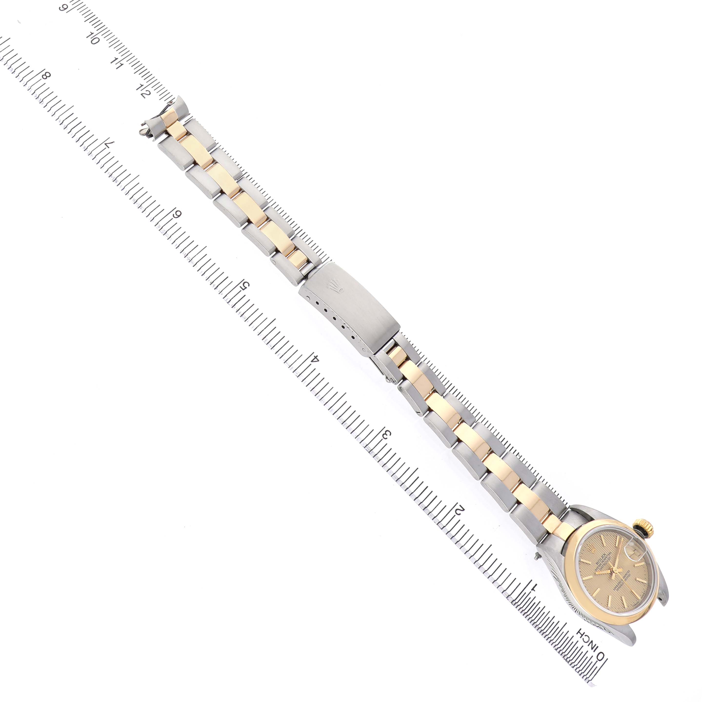 The Rolex Datejust 69163 Women's Steel and Gold (two tone) Champagne Dial watch is shown from a top-down angle, displaying the bracelet, case, and crown alongside a ruler.