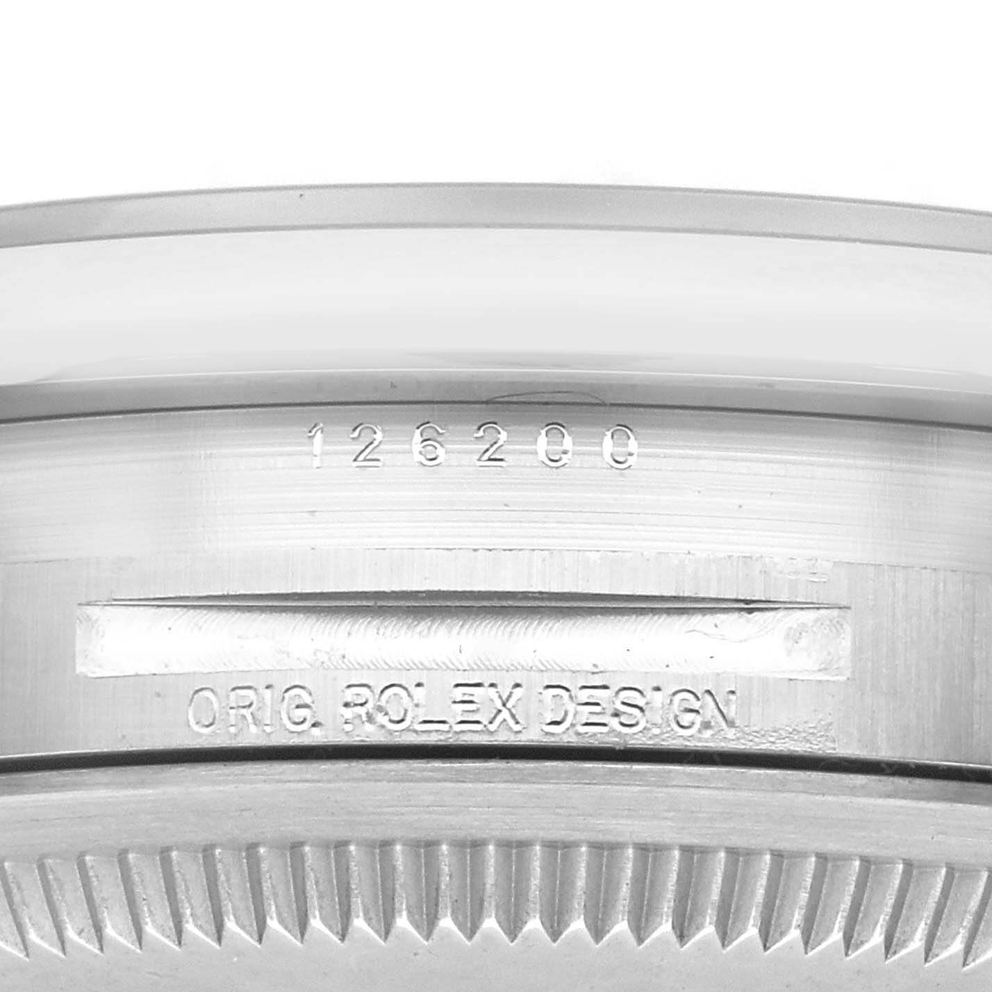 This image shows the side of a Rolex Datejust 126200 Men's Stainless Steel Blue Dial 126200 Men's Stainless Steel Blue Dial model, highlighting the serial number and 'ORIG. ROLEX DESIGN' engraving.