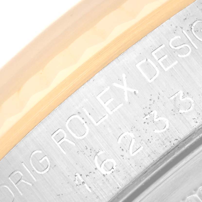 This close-up image shows part of the engraved text on the side of the bezel of a Rolex Datejust 16233 Men's Steel and Gold (two tone) Champagne Dial 16233 Men's Steel and Gold (two tone) Champagne Dial watch.