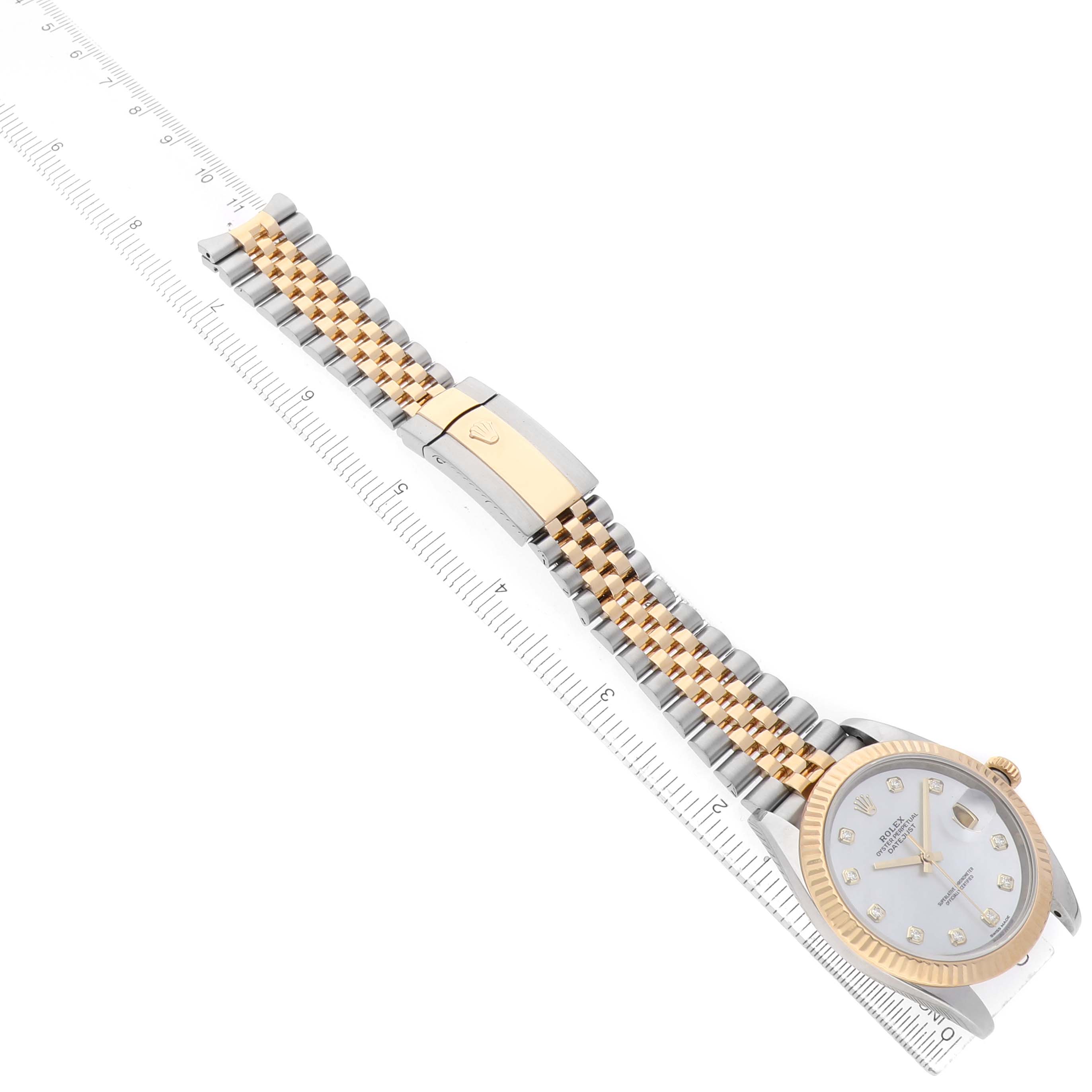 The Rolex Datejust 41 126333 Men's Steel and Gold (two tone) Mother of Pearl Dial is shown from a top-down angle, displaying the dial, bezel, and the full bracelet extended alongside a ruler.